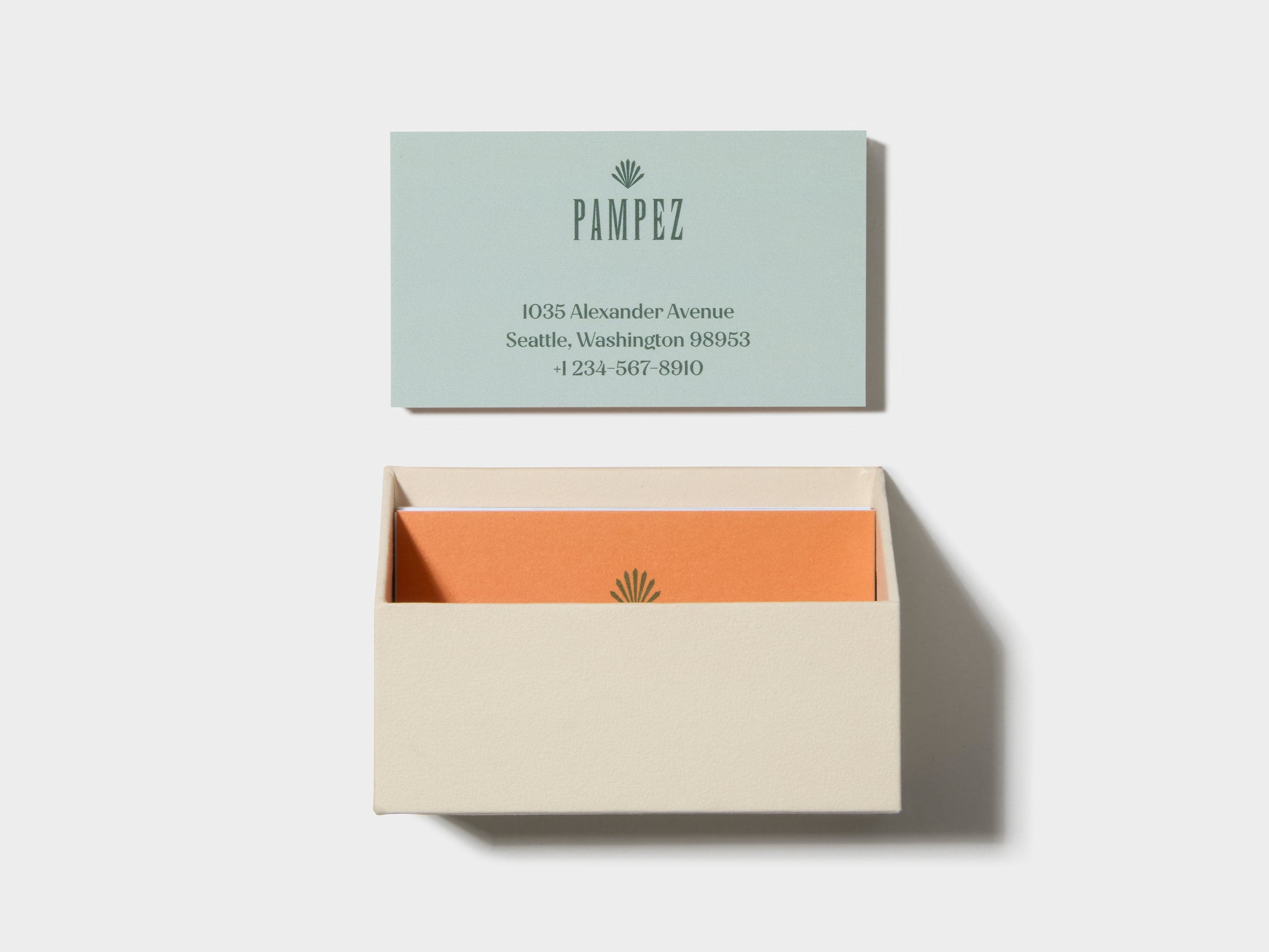 An open off white business card box with customised luxe business cards place inside and above.