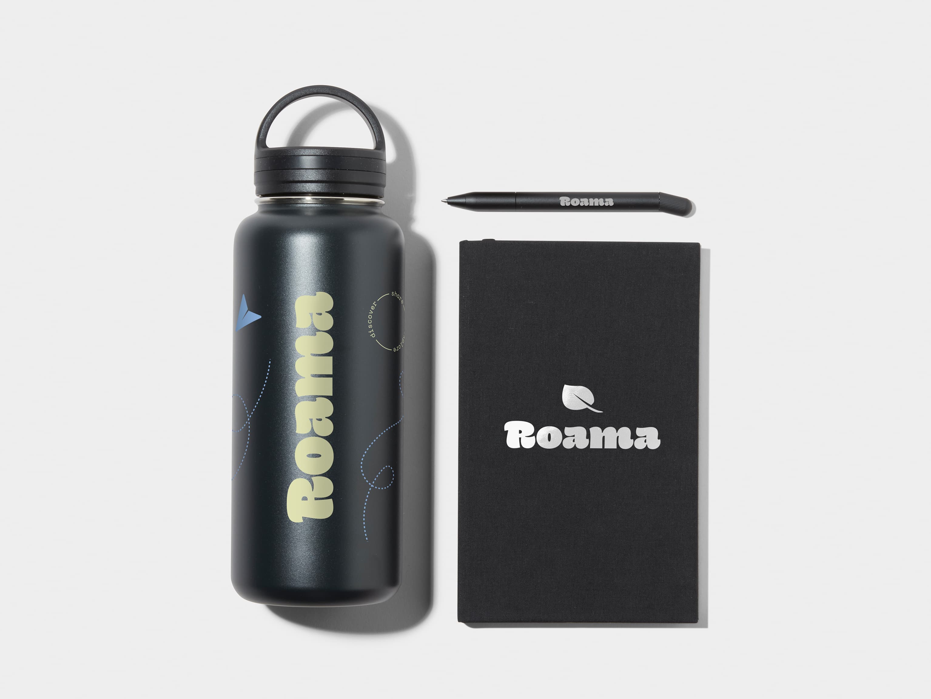 Large Insulated Water Bottle in Jet Black with 360 wrap printing customisation next to a Jet Black Hard Cover Notebook and MOO Twist Pen with custom branding