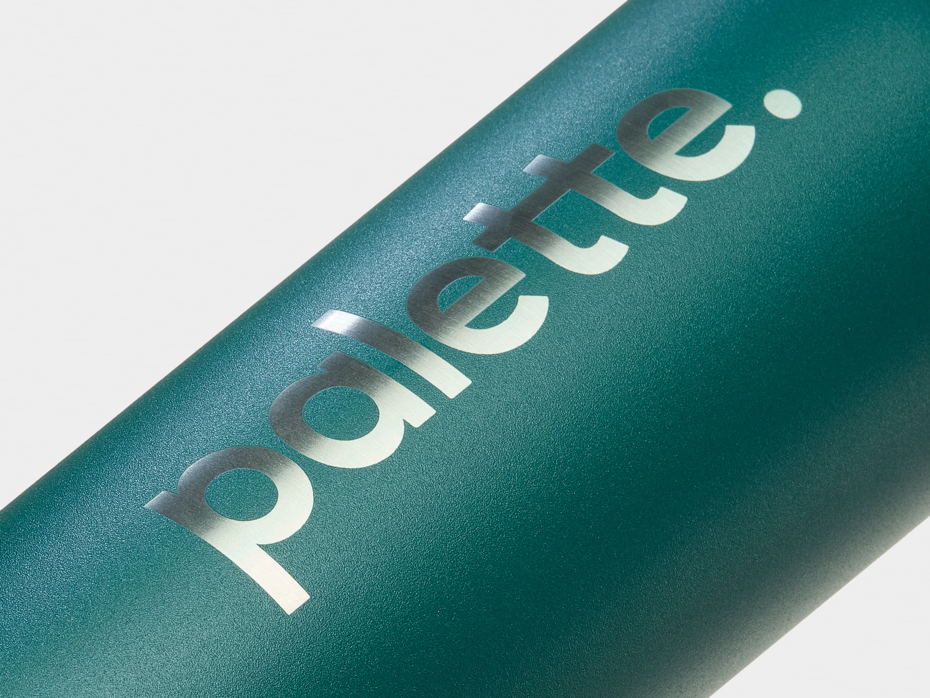 A detail image of custom silver branding on a green water bottle.