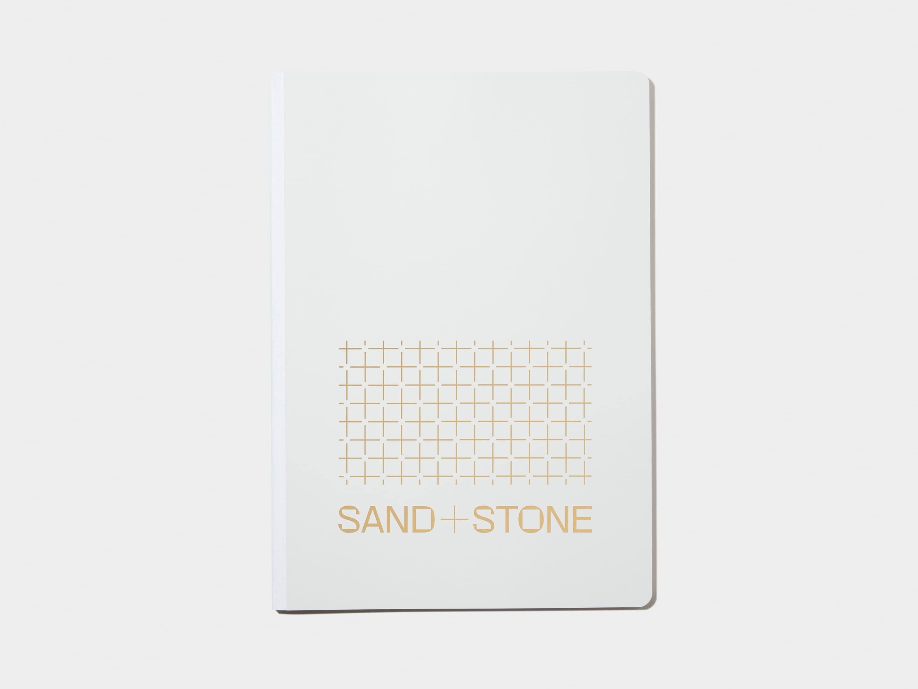 A large cloudy grey softcover notebook with gold foil customisation.