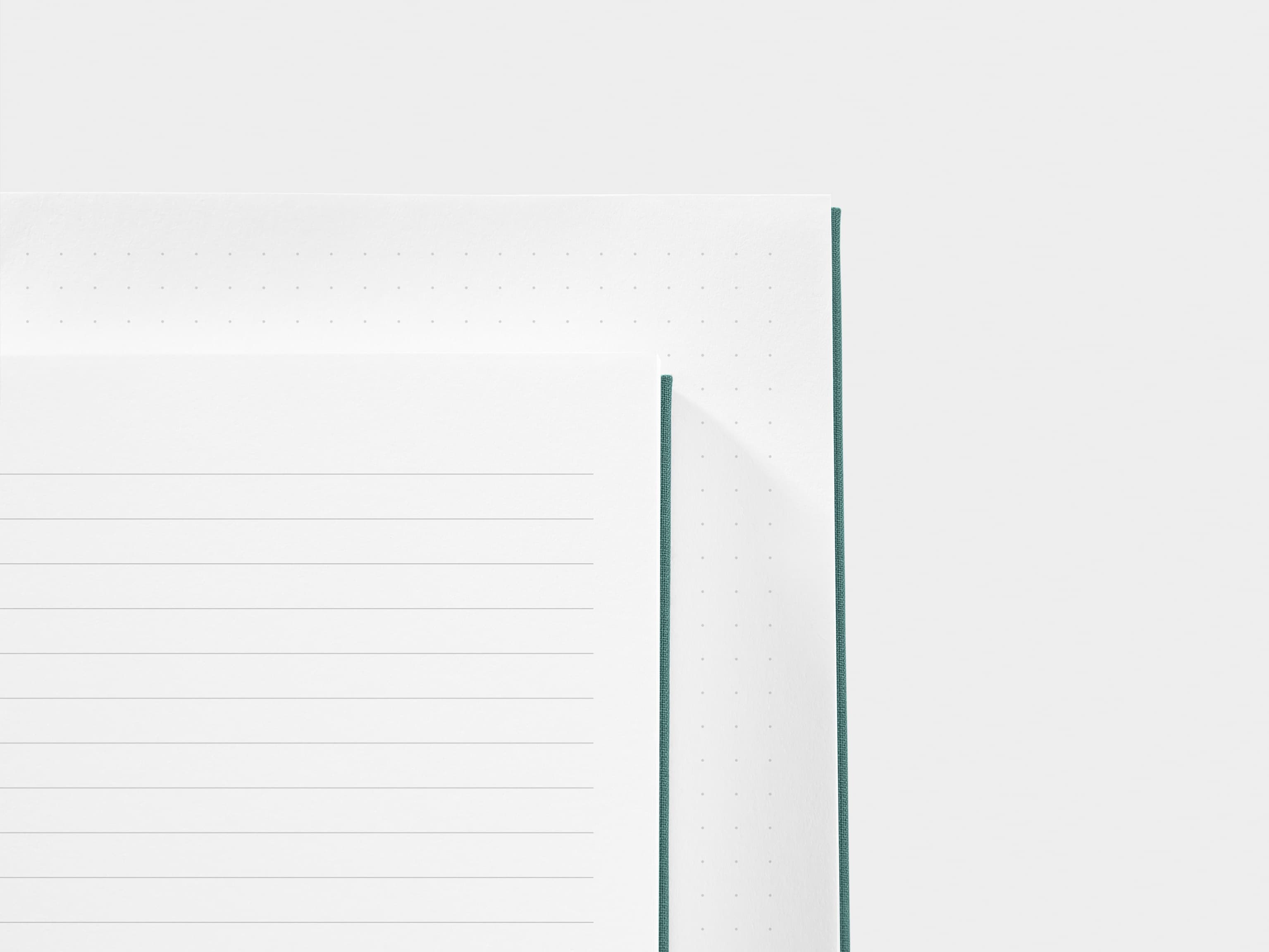 A close up of a dotted paper and a lined paper next to each other 