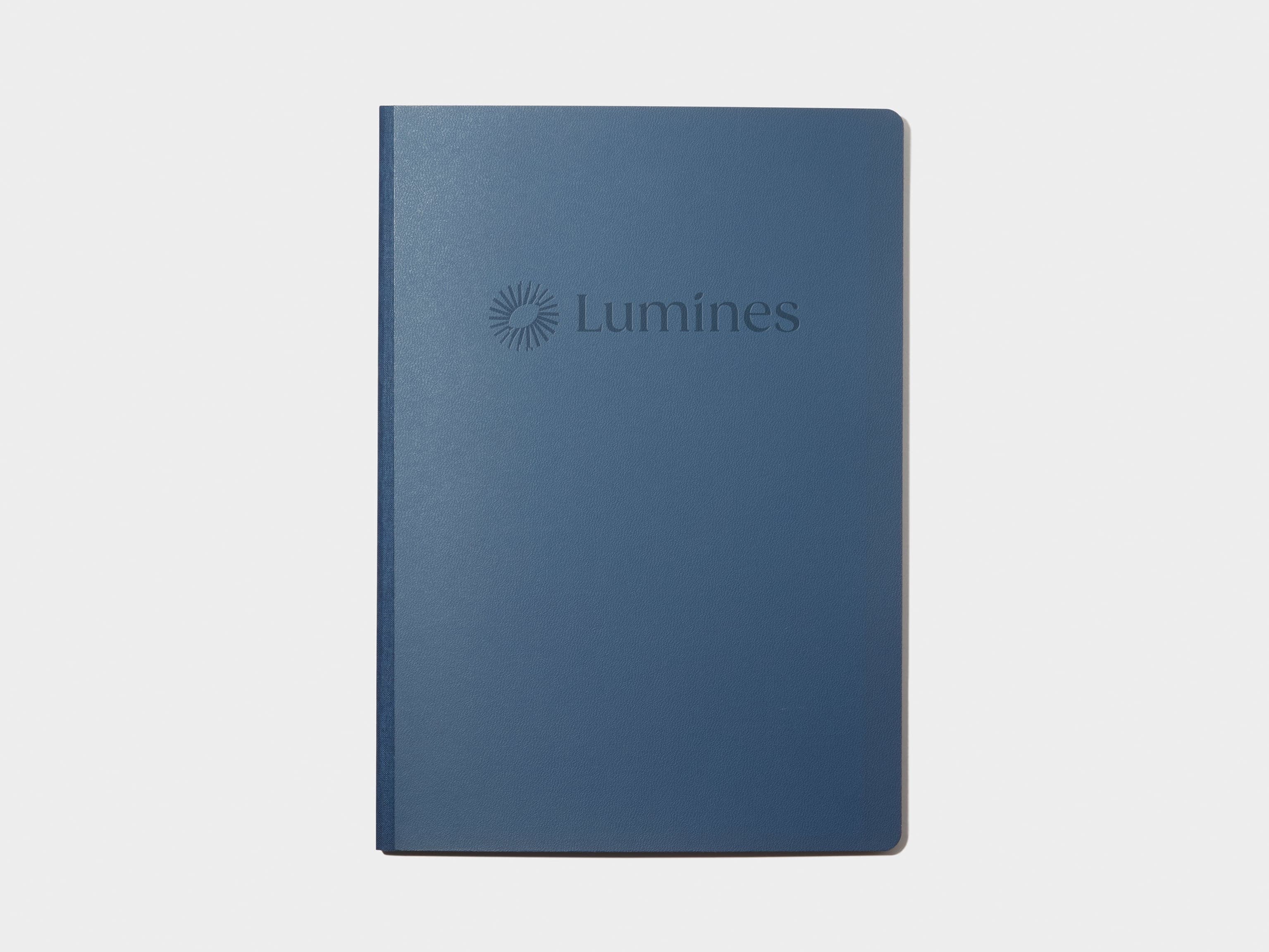 A blue softcover planner with custom branding in deboss.