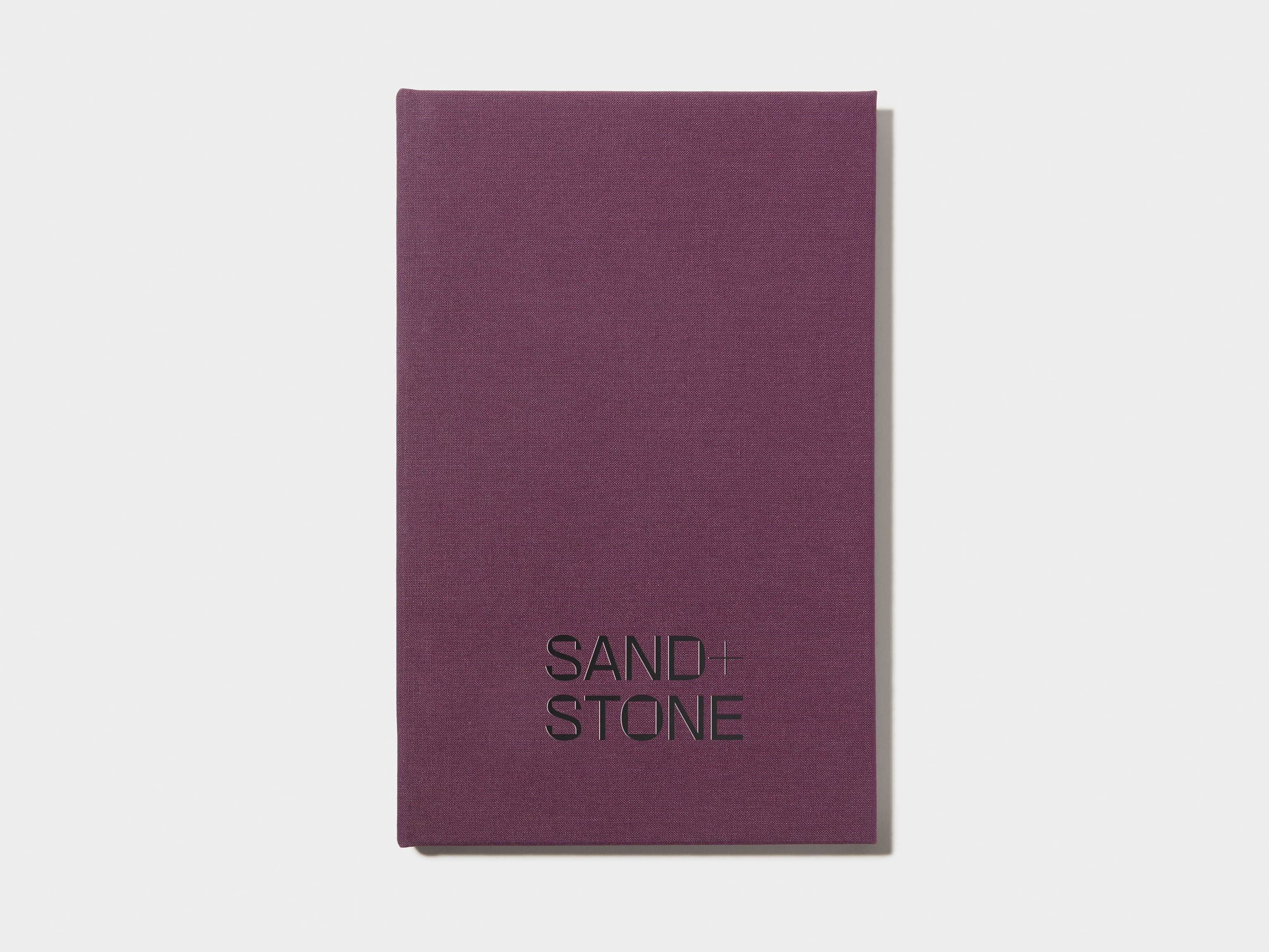 A mulberry coloured hardcover notebook with black foil customisation on the front.