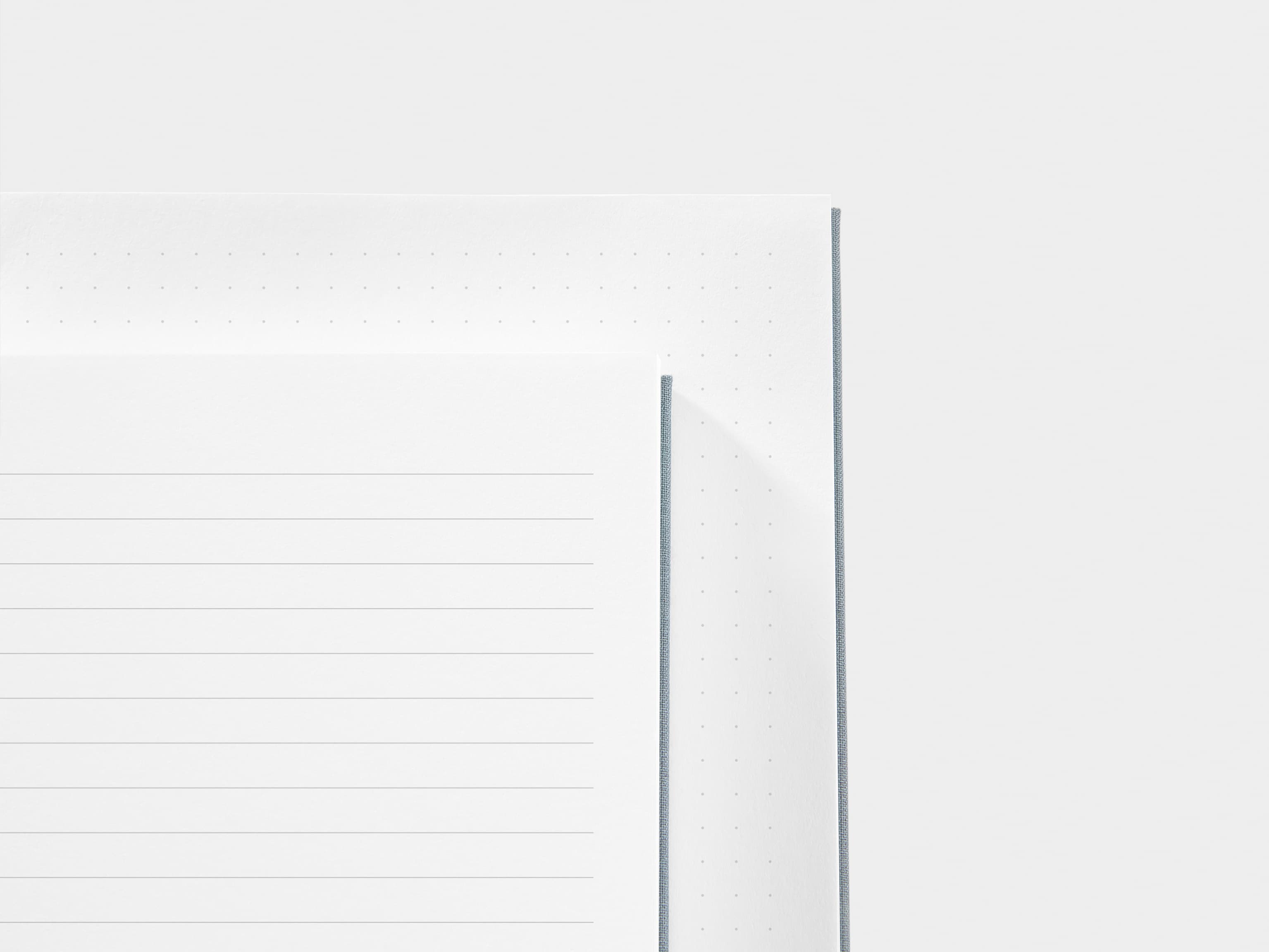 A close up of a dotted paper and a lined paper next to each other 