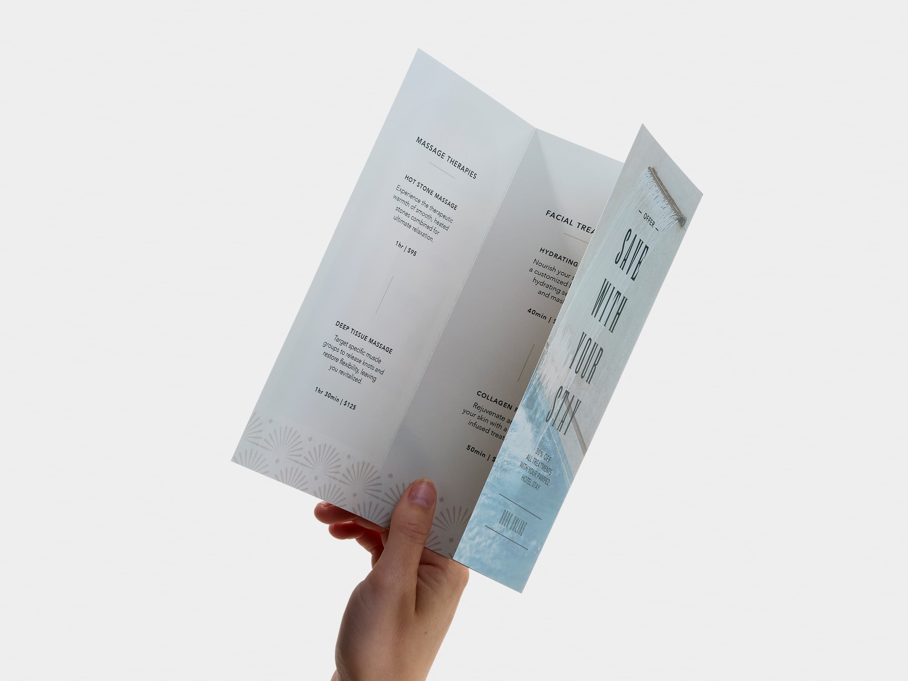 A hand holding a tri-fold gloss paper brochure.