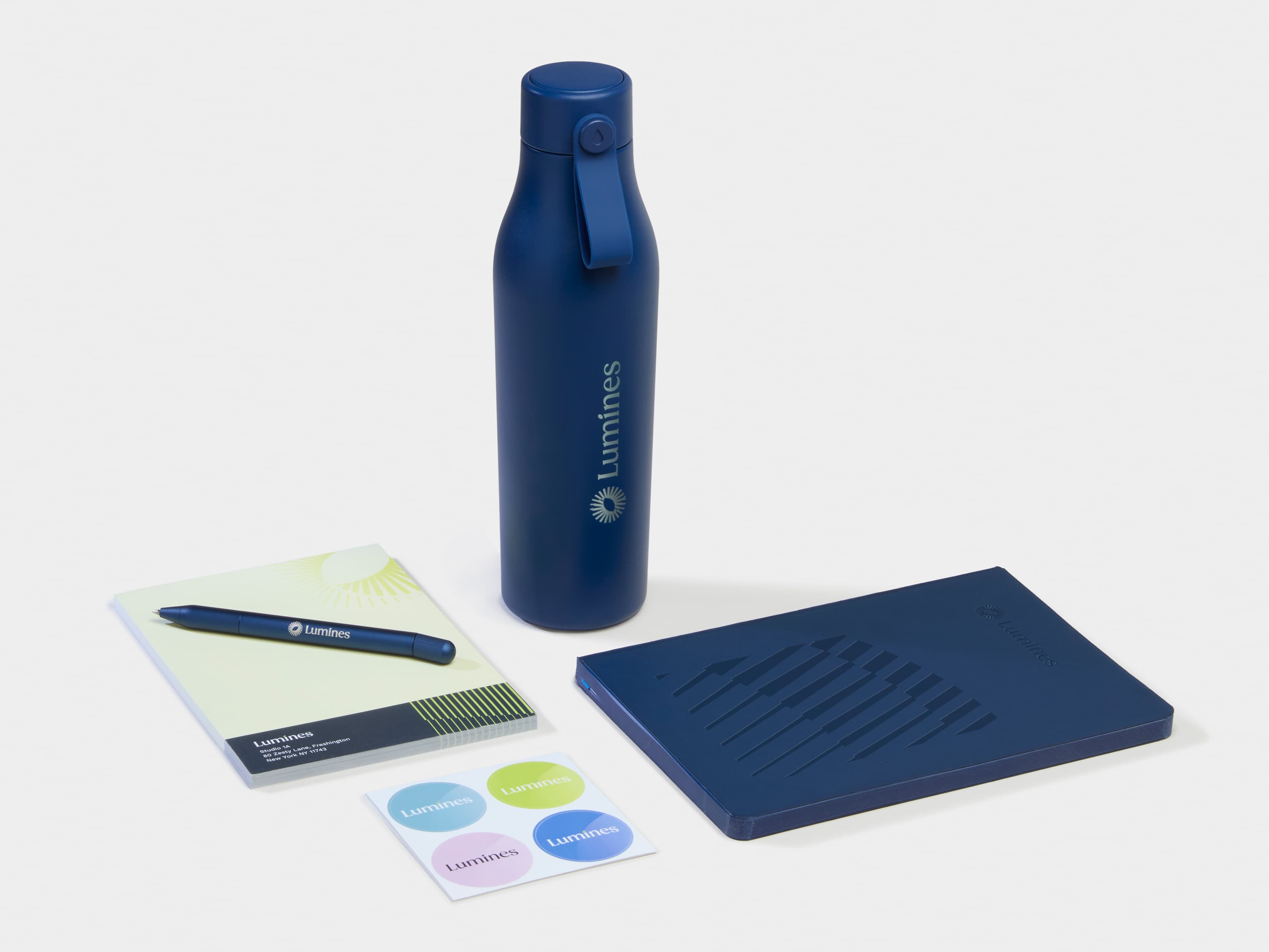 A collection of Branded Merchandise including a blue water bottle, notebook and pen.