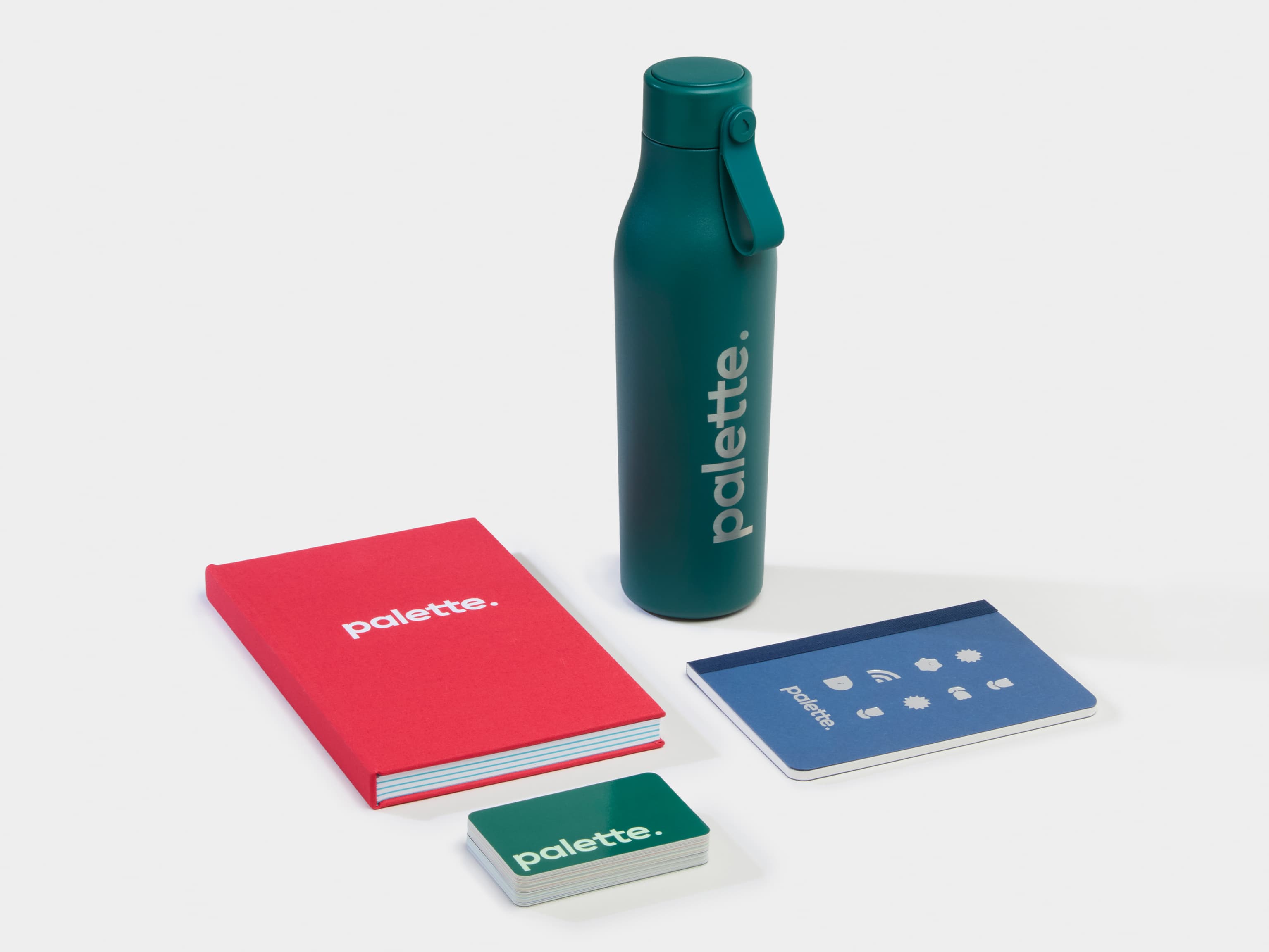 A collection of Branded Merchandise products including a green water bottle, business cards and notebooks.