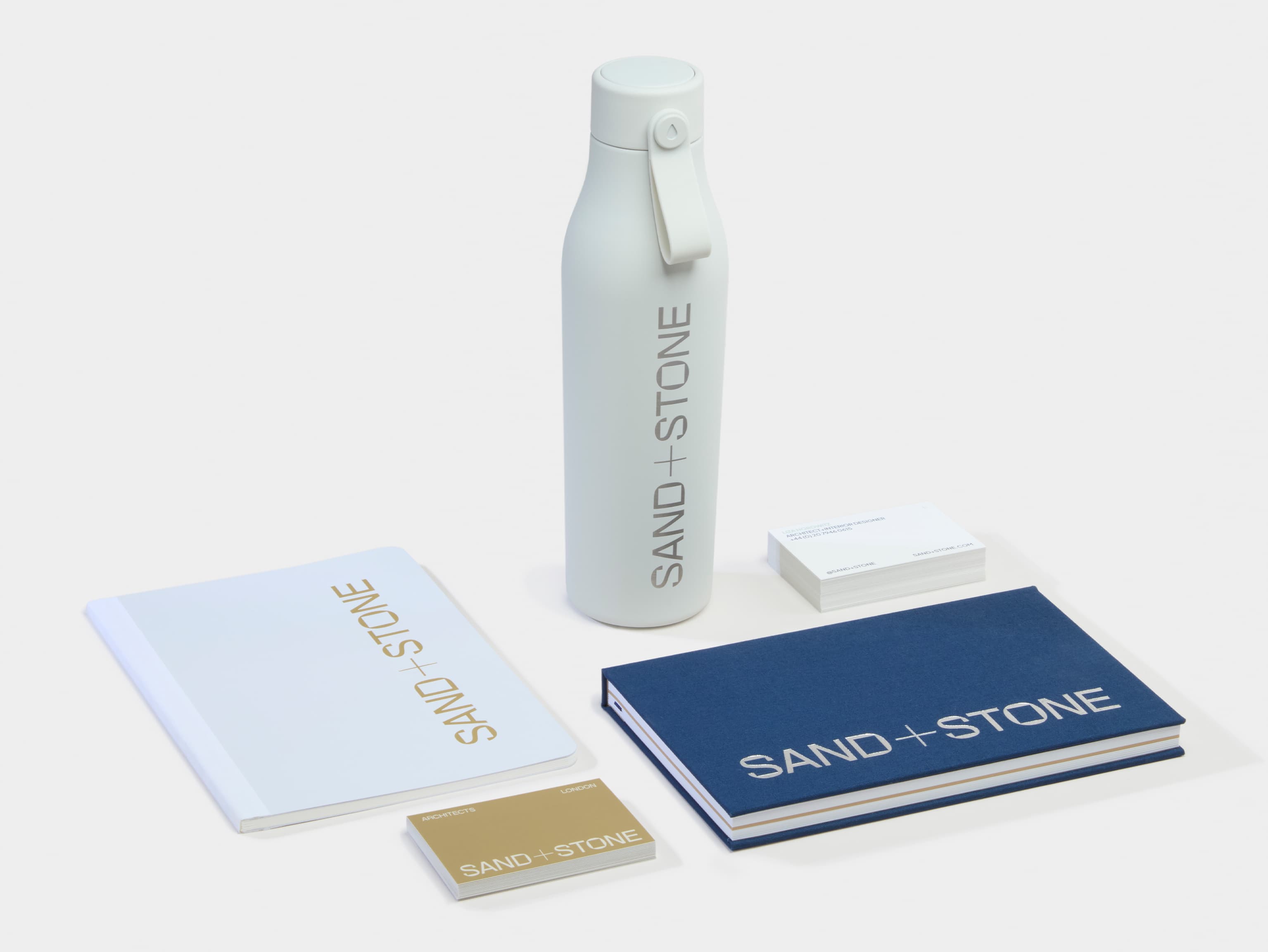 A collection of Branded Merchandise products including a water bottle, business cards and two notebooks.