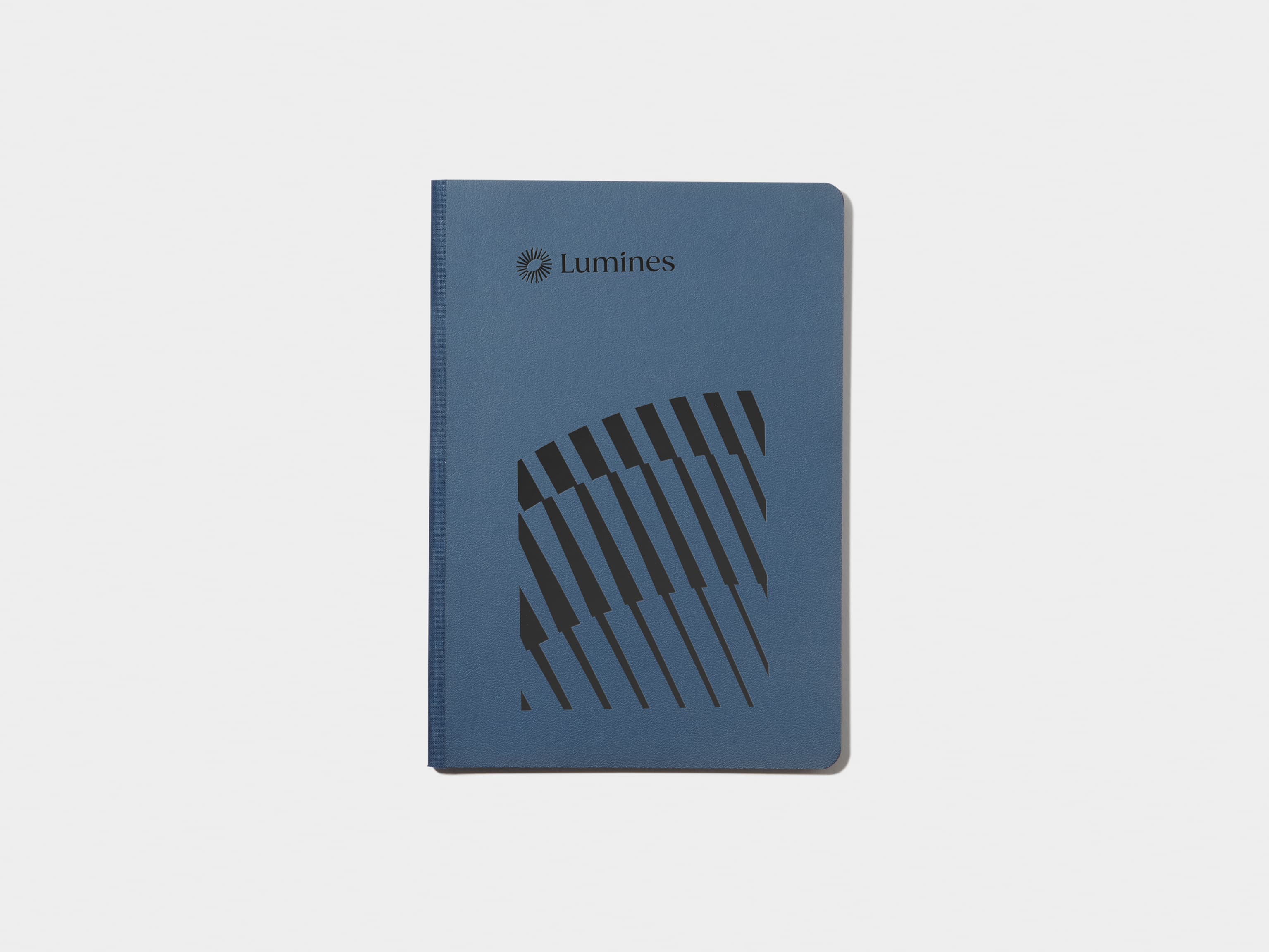 A midnight blue softcover notebook with black foil customisation.