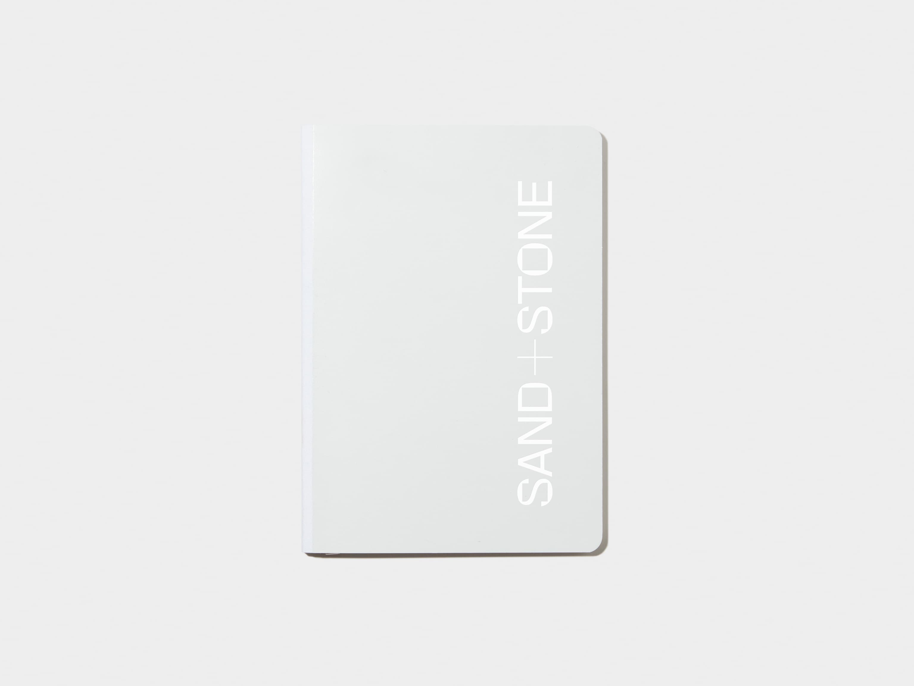 A cloudy grey softcover notebook with white foil customisation.