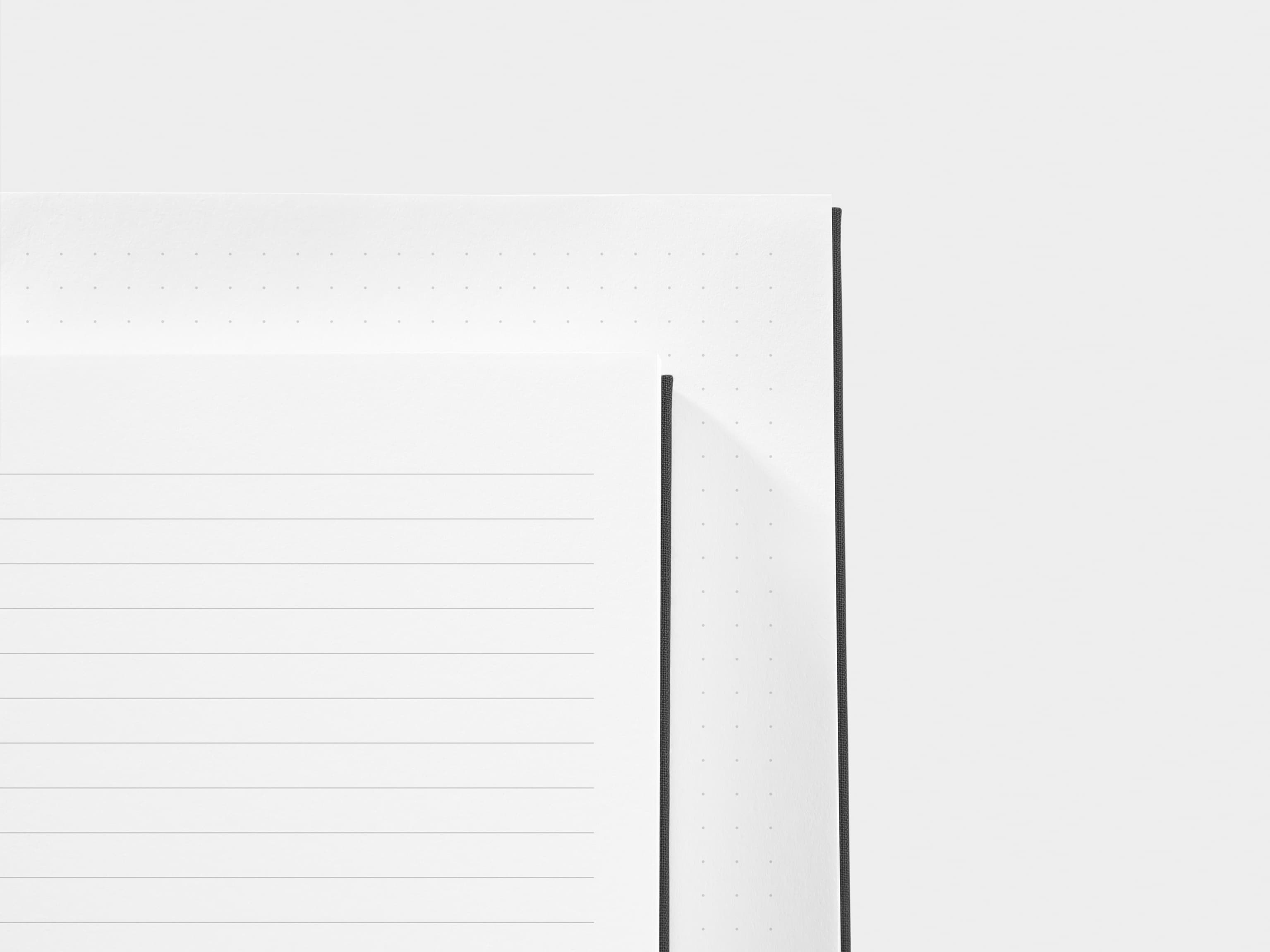 A close up of a dotted paper and a lined paper next to each other 