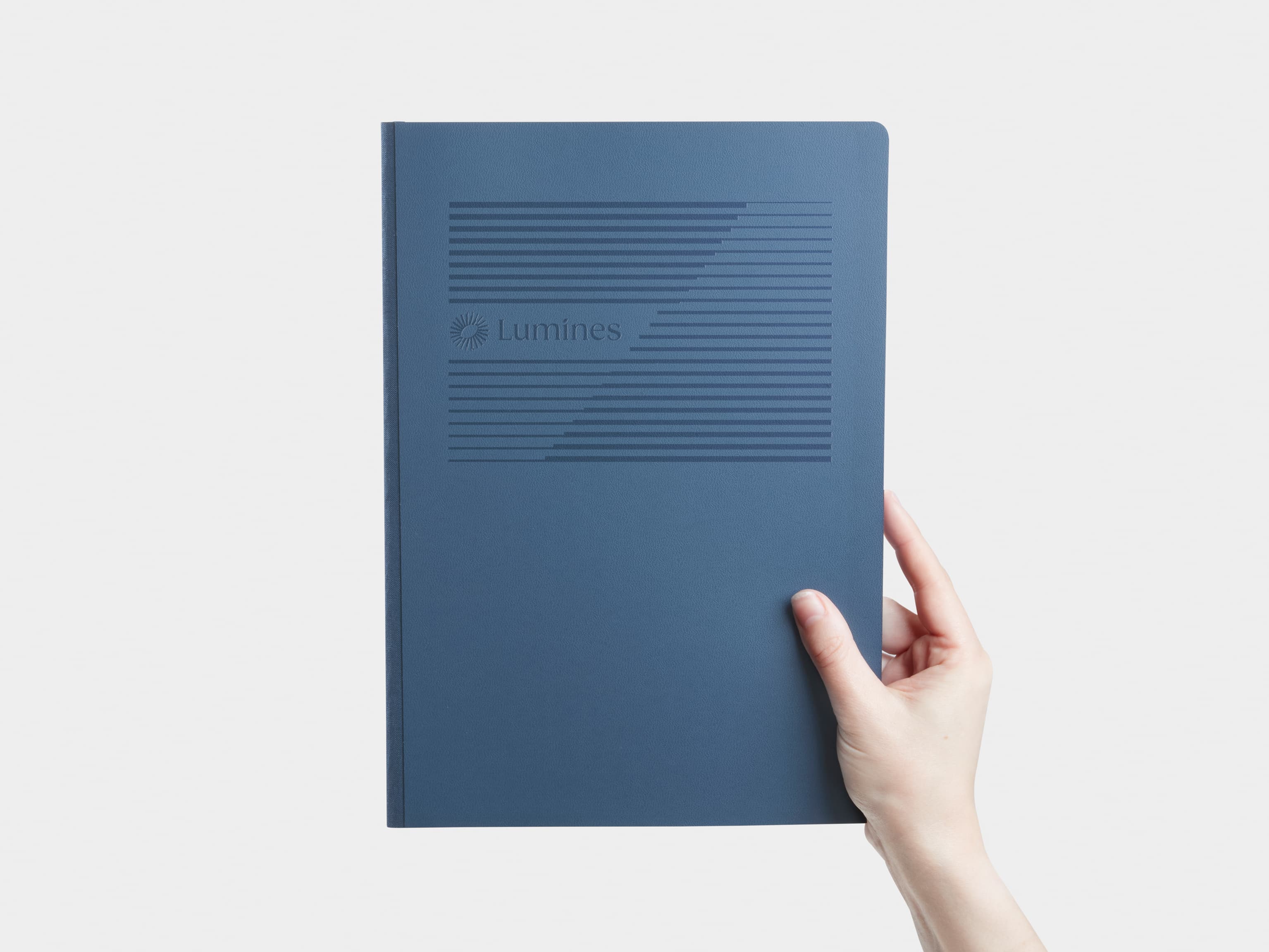 Hand holding a Large Midnight Blue MOO Softcover Notebook with Blind Deboss finish