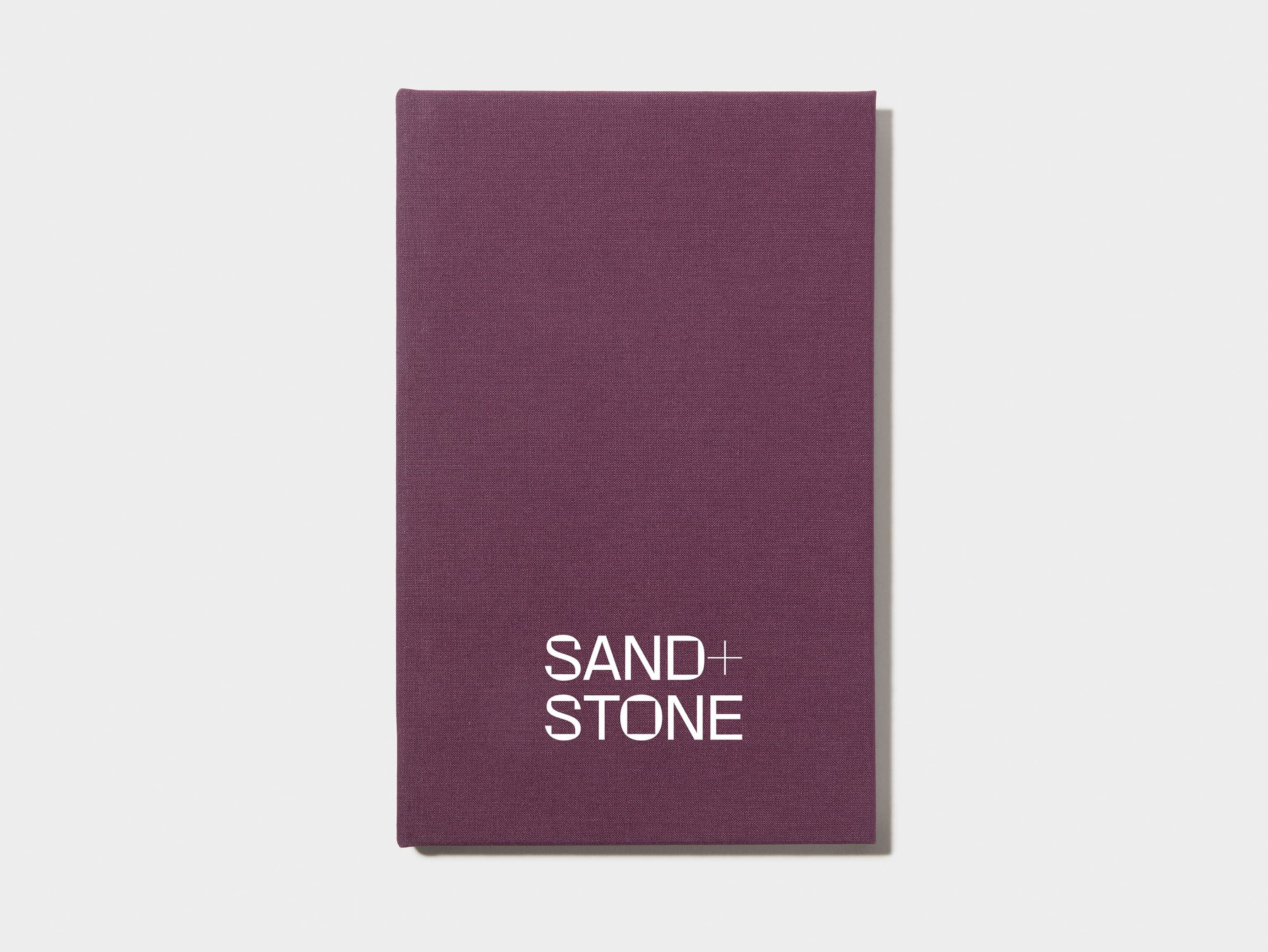 A mulberry coloured hardcover notebook with white foil customisation on the front.