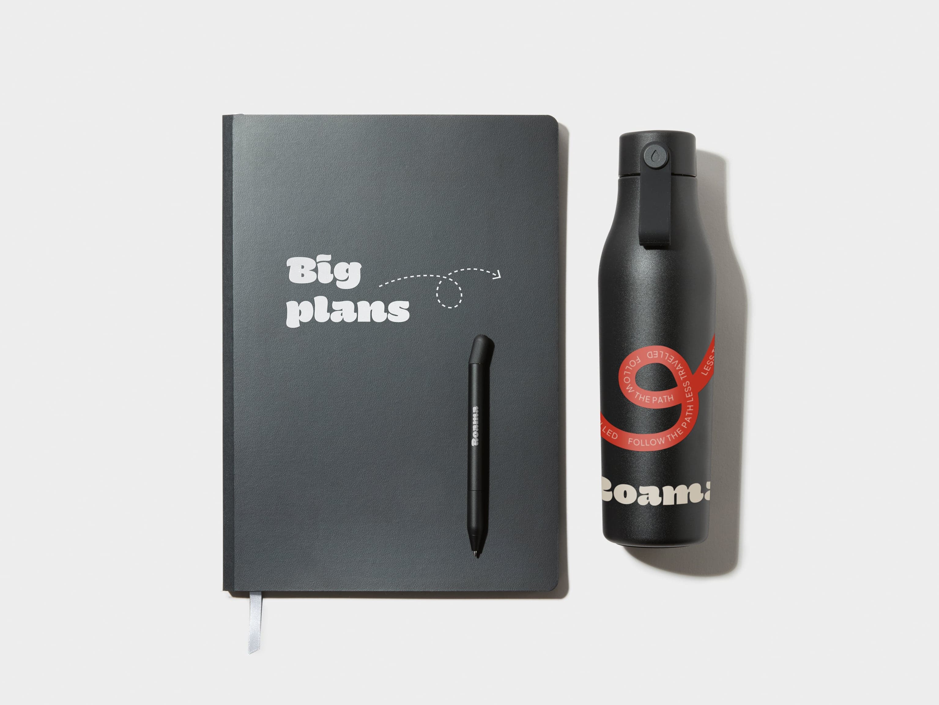 A collection of customised products including a black water bottle, pen and softcover planner.