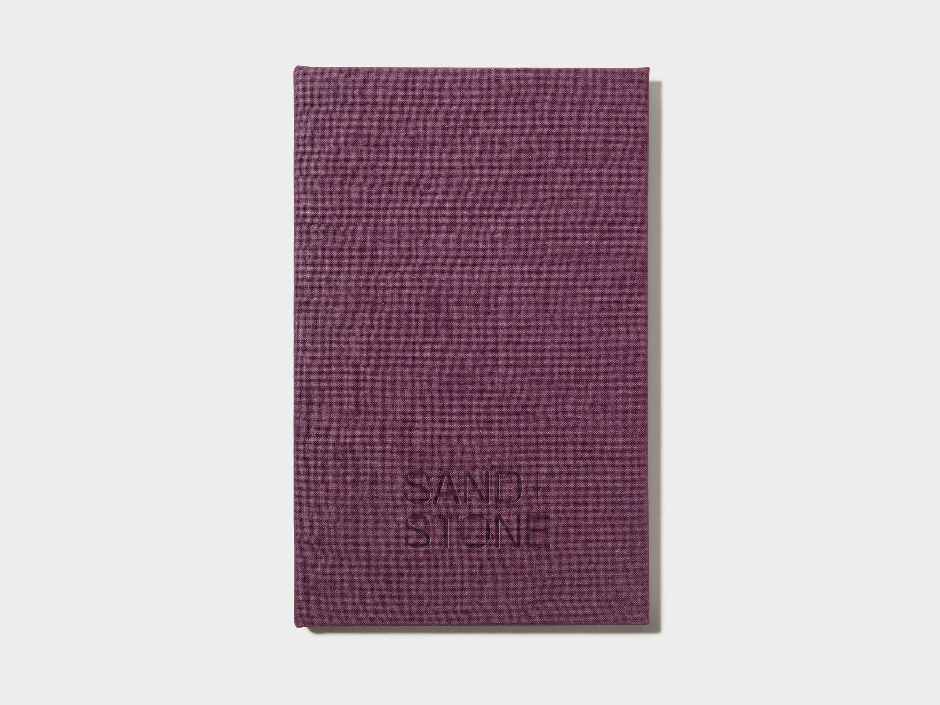 A mulberry coloured hardcover notebook with blind deboss customisation on the front.