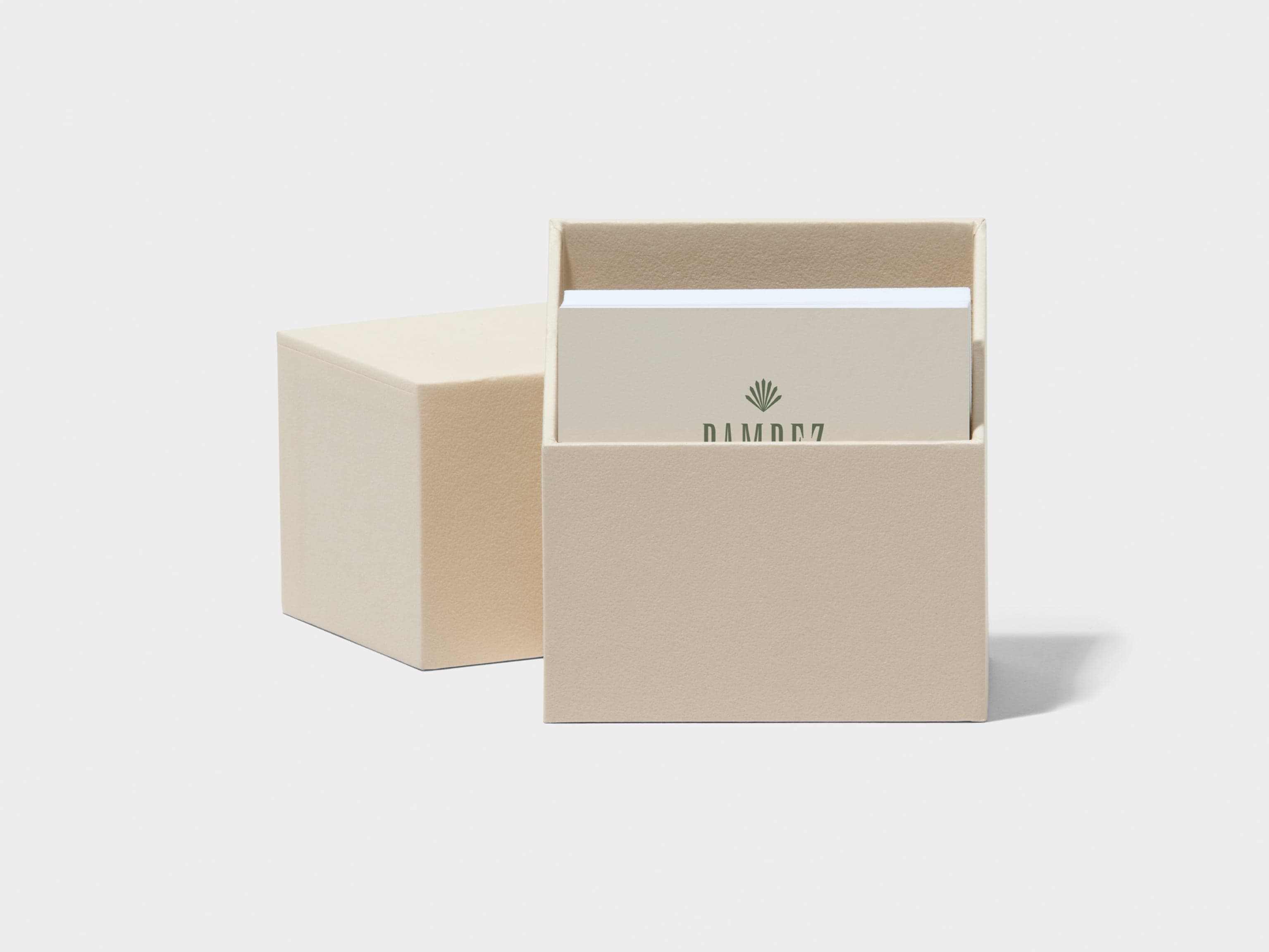 An open square business card box with white custom luxe business cards placed inside.