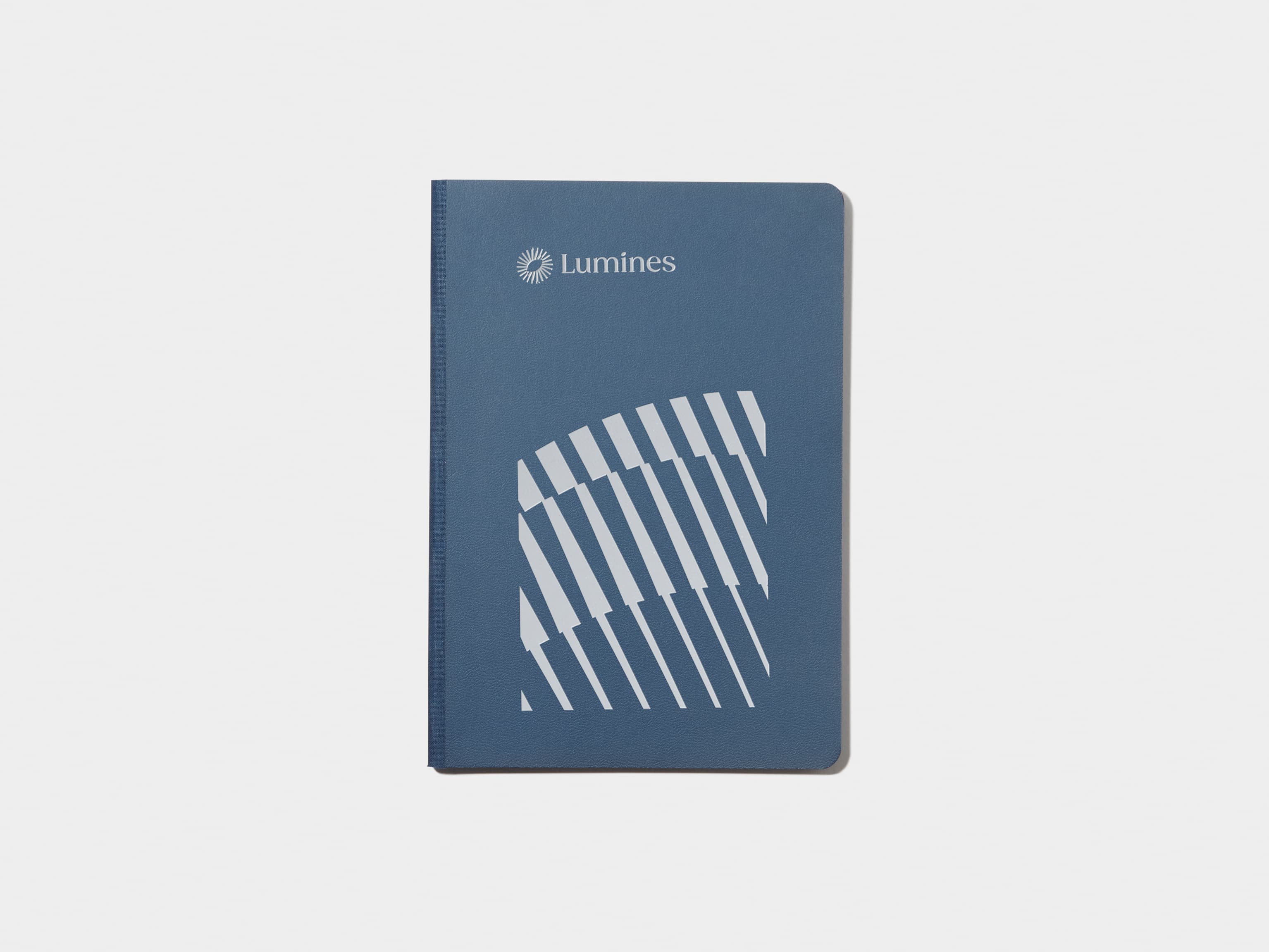 A midnight blue softcover notebook with silver foil customisation.