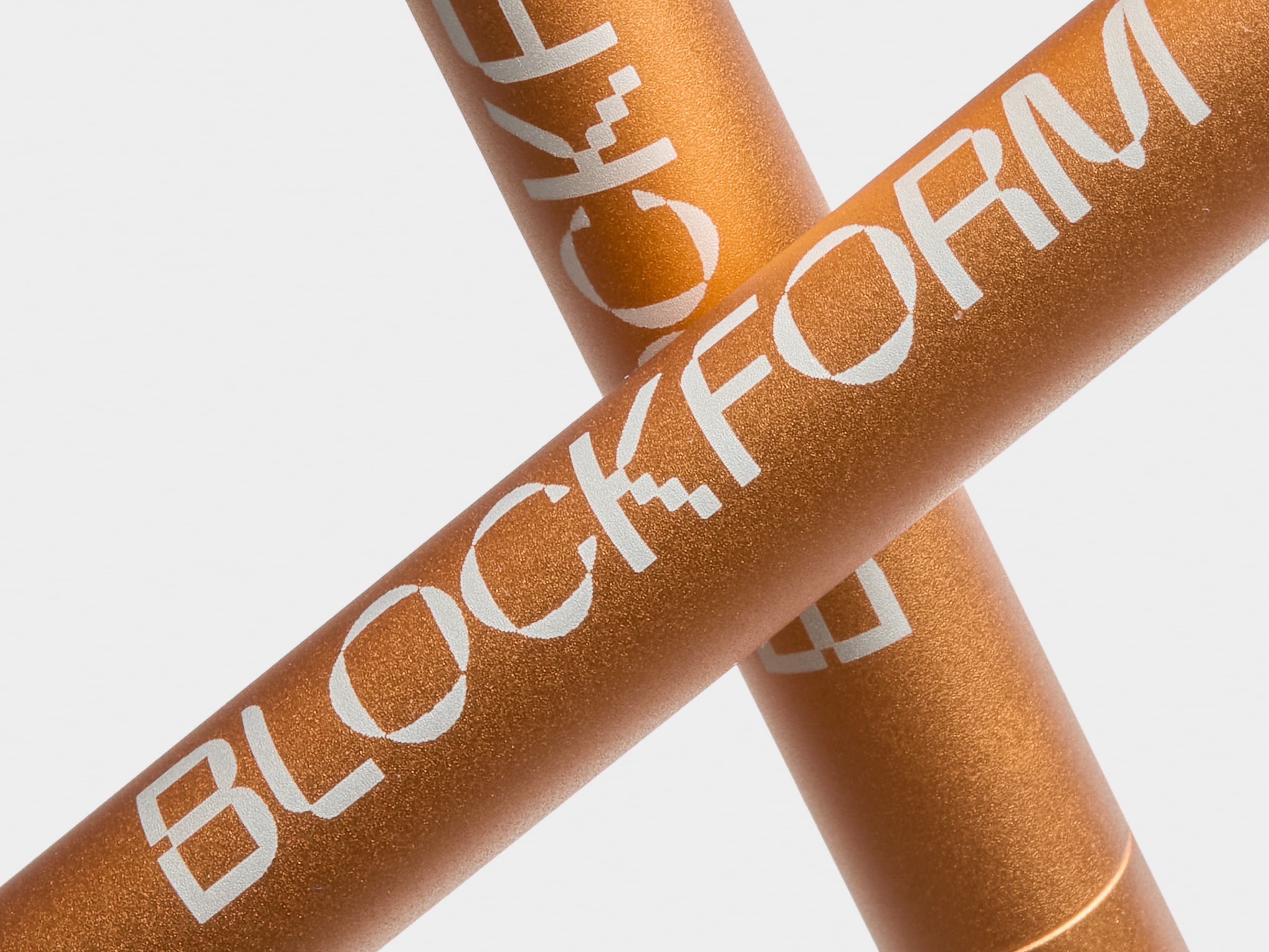 A detail image of two custom orange pens crossed over each other.