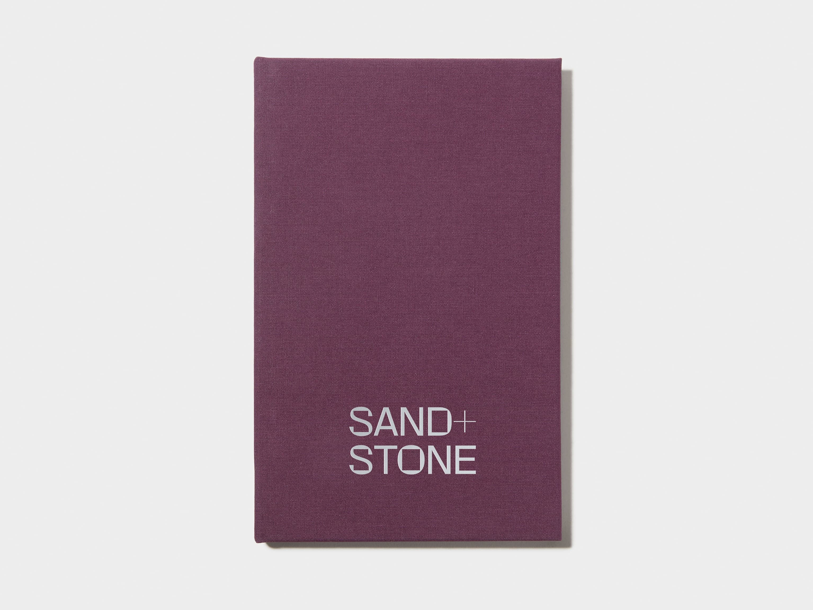 A mulberry coloured hardcover notebook with silver foil customisation on the front.