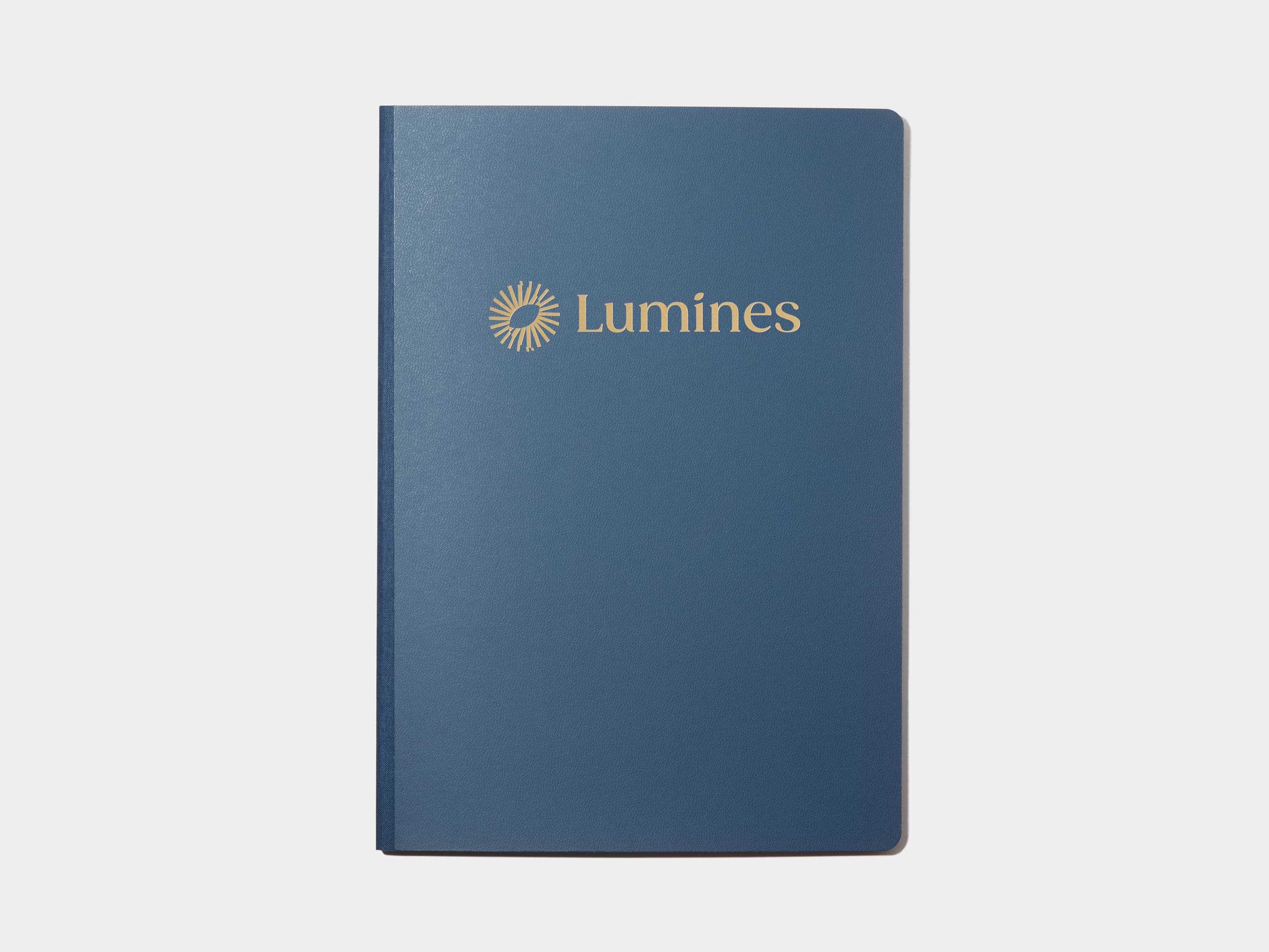 A blue softcover planner with custom branding in gold foil.