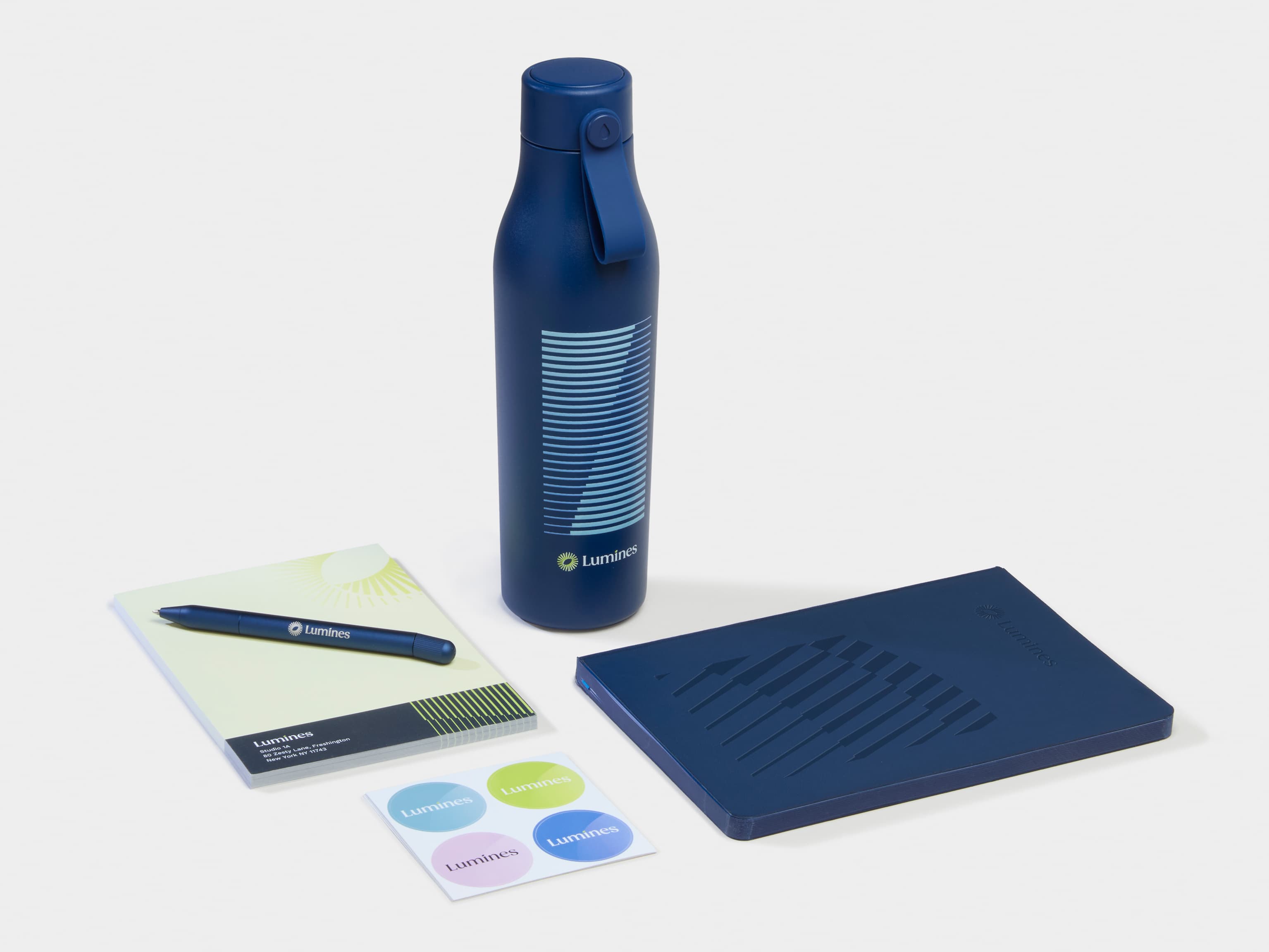 A collection of blue Branded Merchandise including a water bottle, pen and notebook.