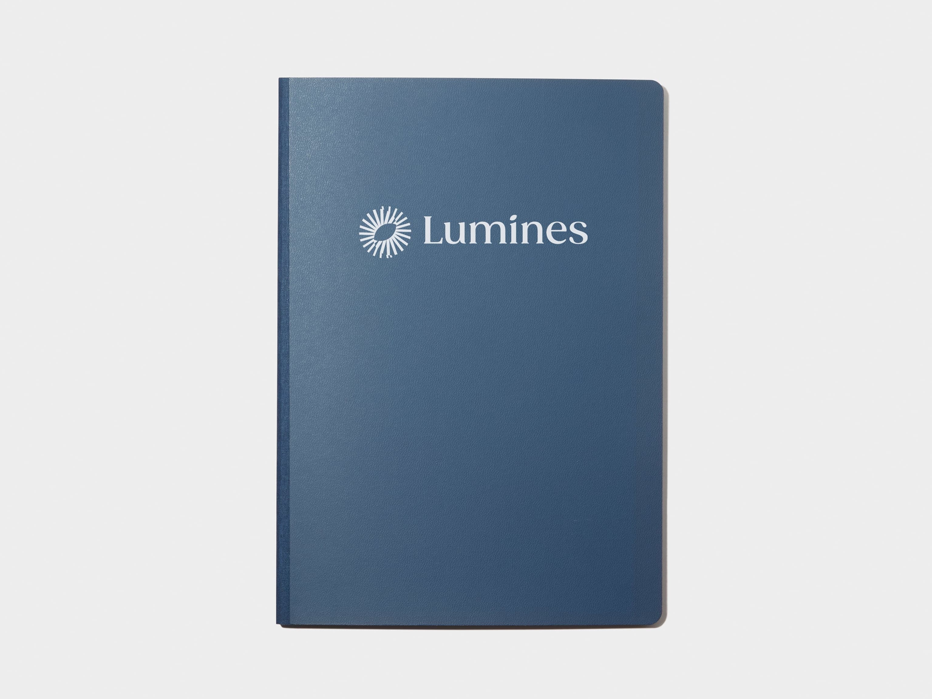 A blue softcover planner with custom branding in white foil.