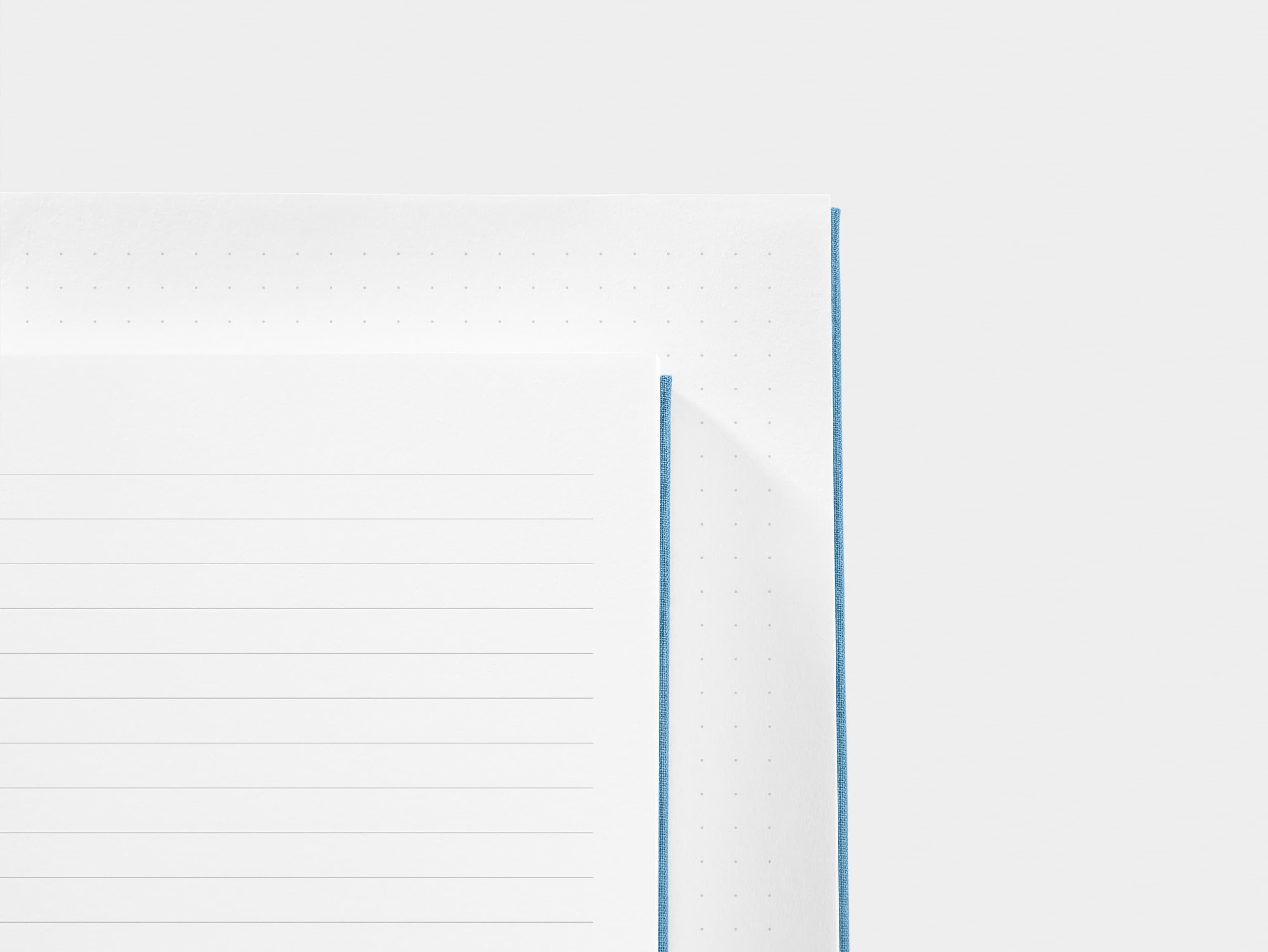 A close up of a dotted paper and a lined paper next to each other 