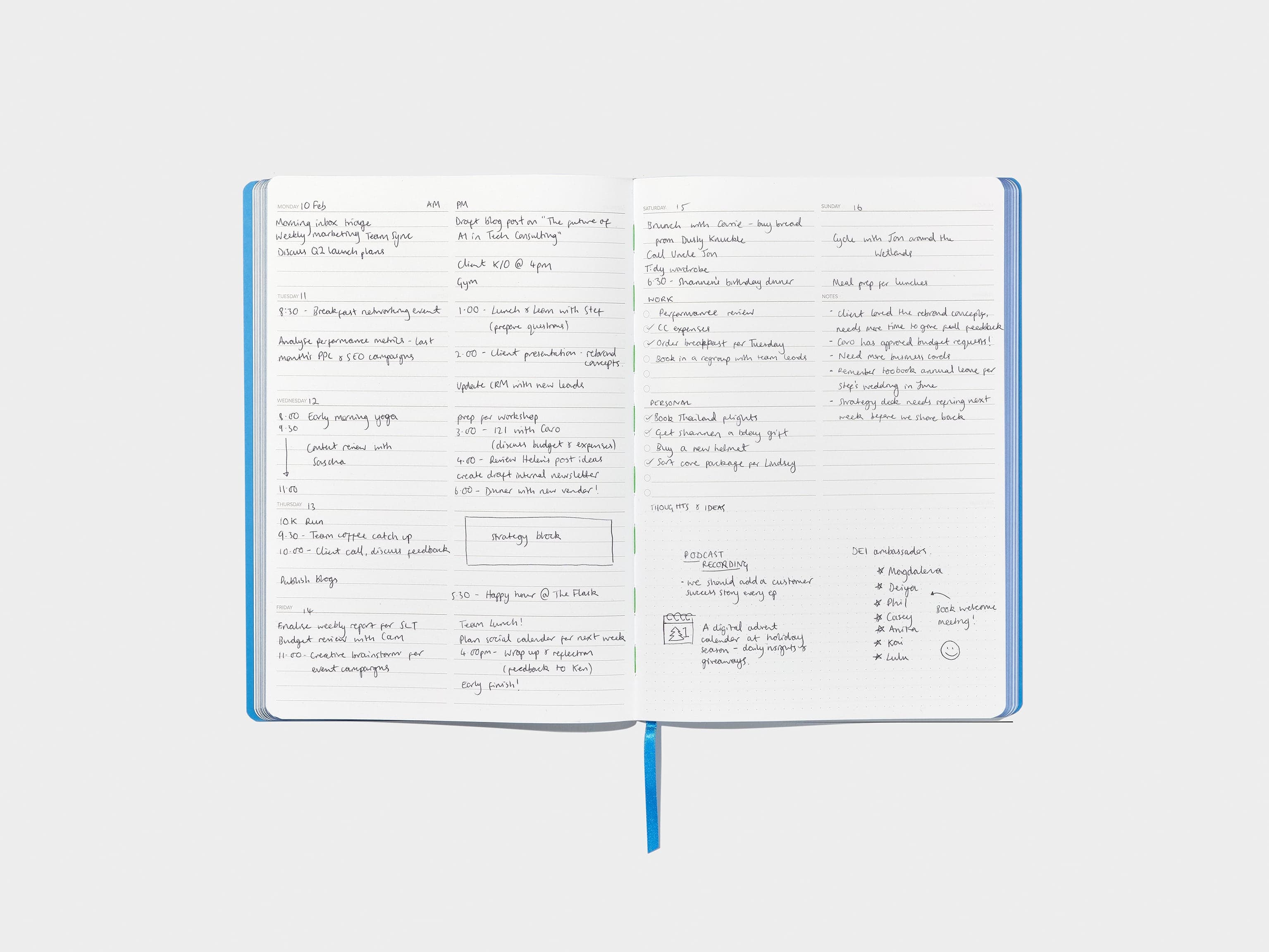 An open blue softcover planner with writing in it.