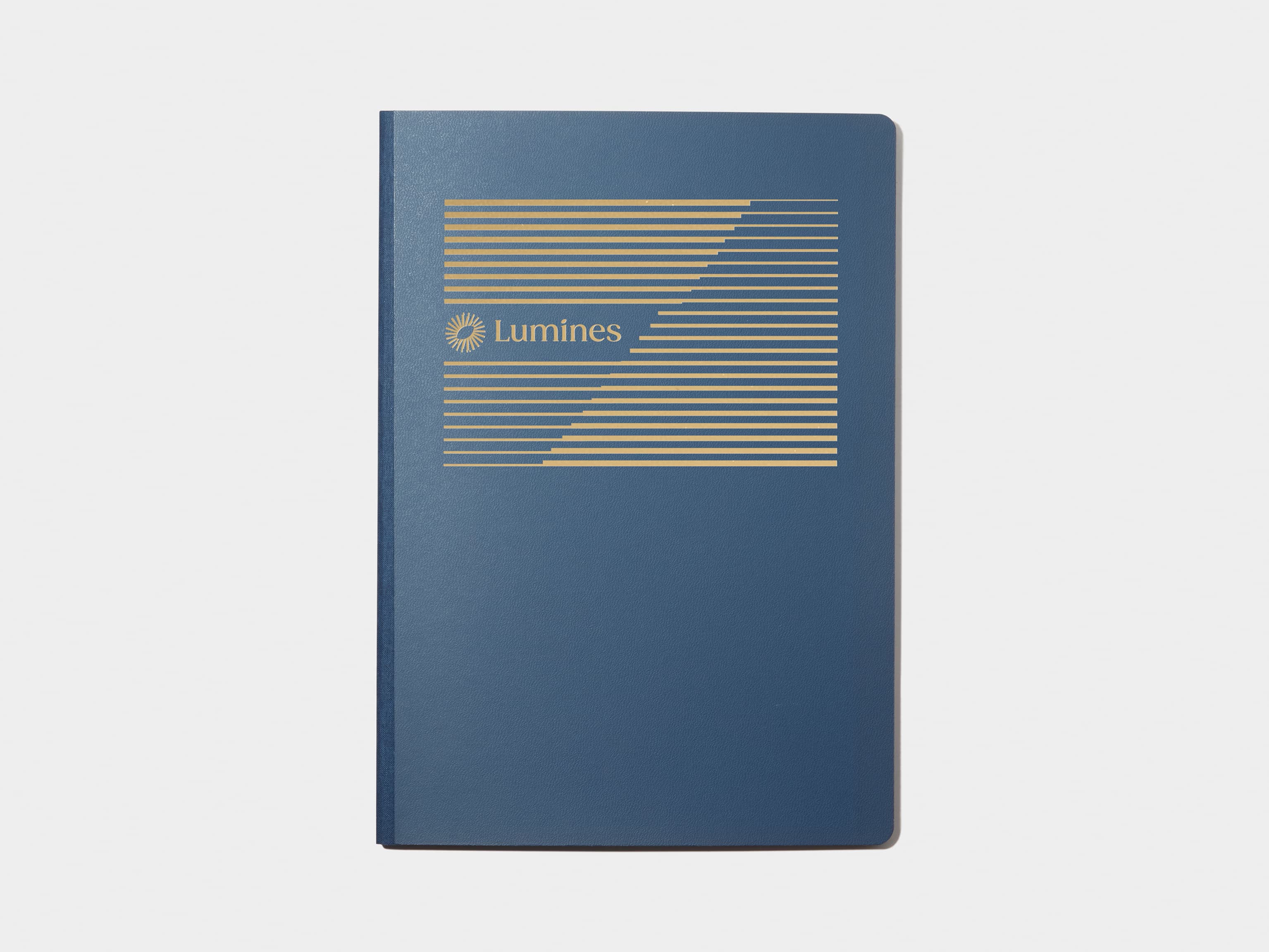 A large midnight blue softcover notebook with gold foil customisation.