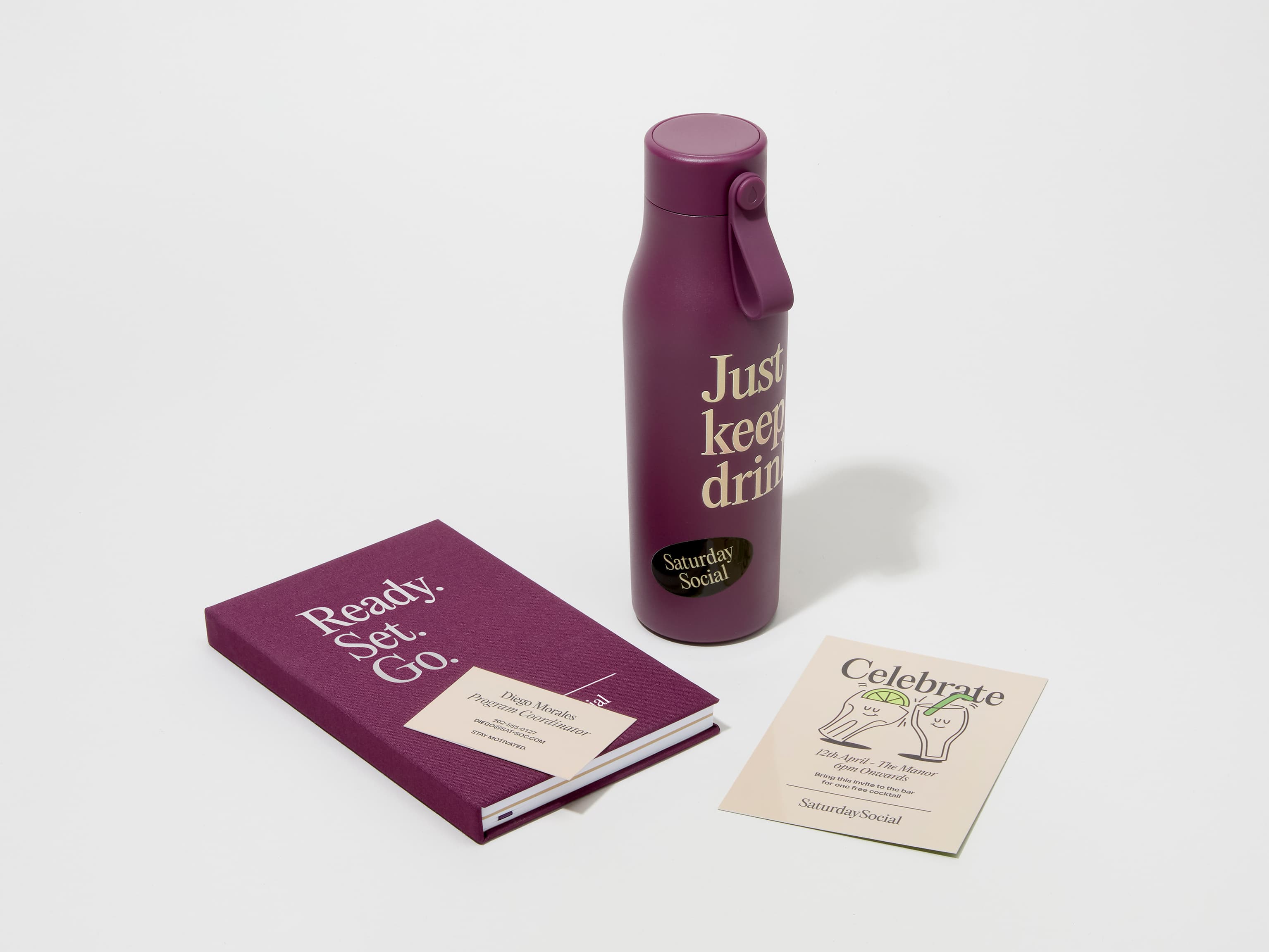 A collection of branded merchandise including a mulberry MOO water bottle with customized 360 wrap printing alongside a notepad, notebook and pen.