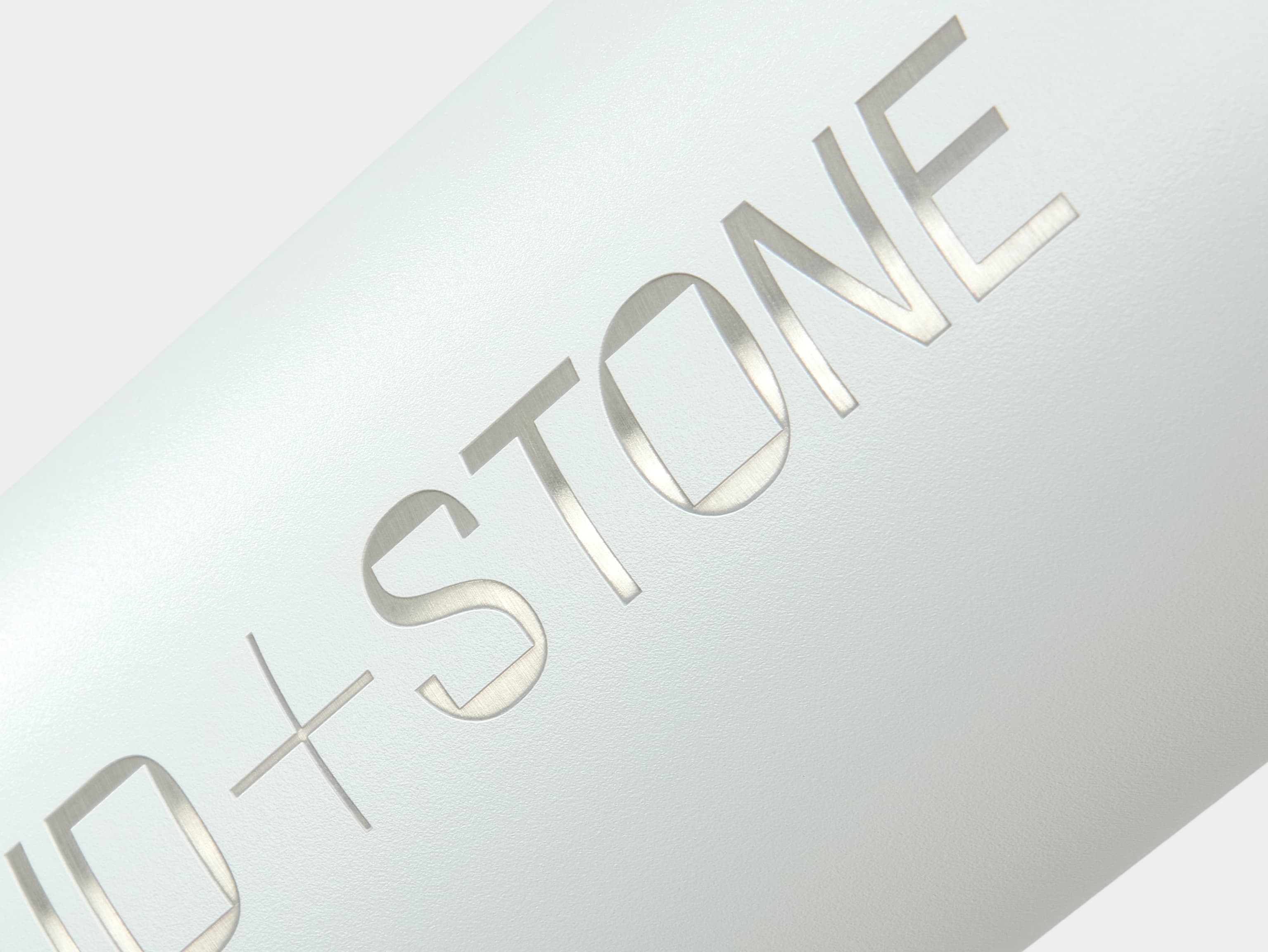 Close up image of custom engraving on a cloudy grey MOO water bottle.