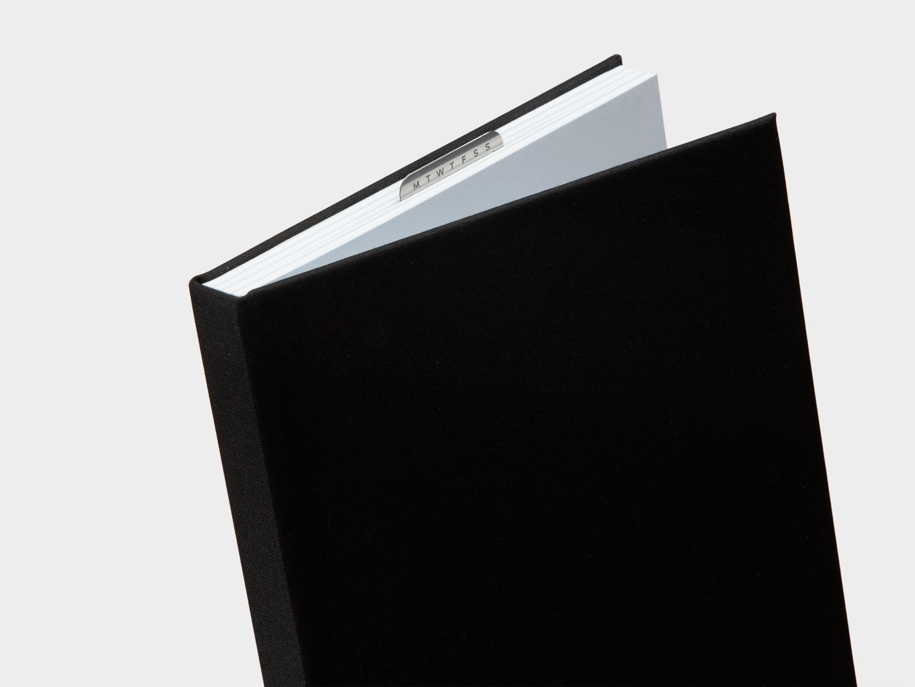 Half Opened Jet Black  Cloth Planner with a silver clip sticking out