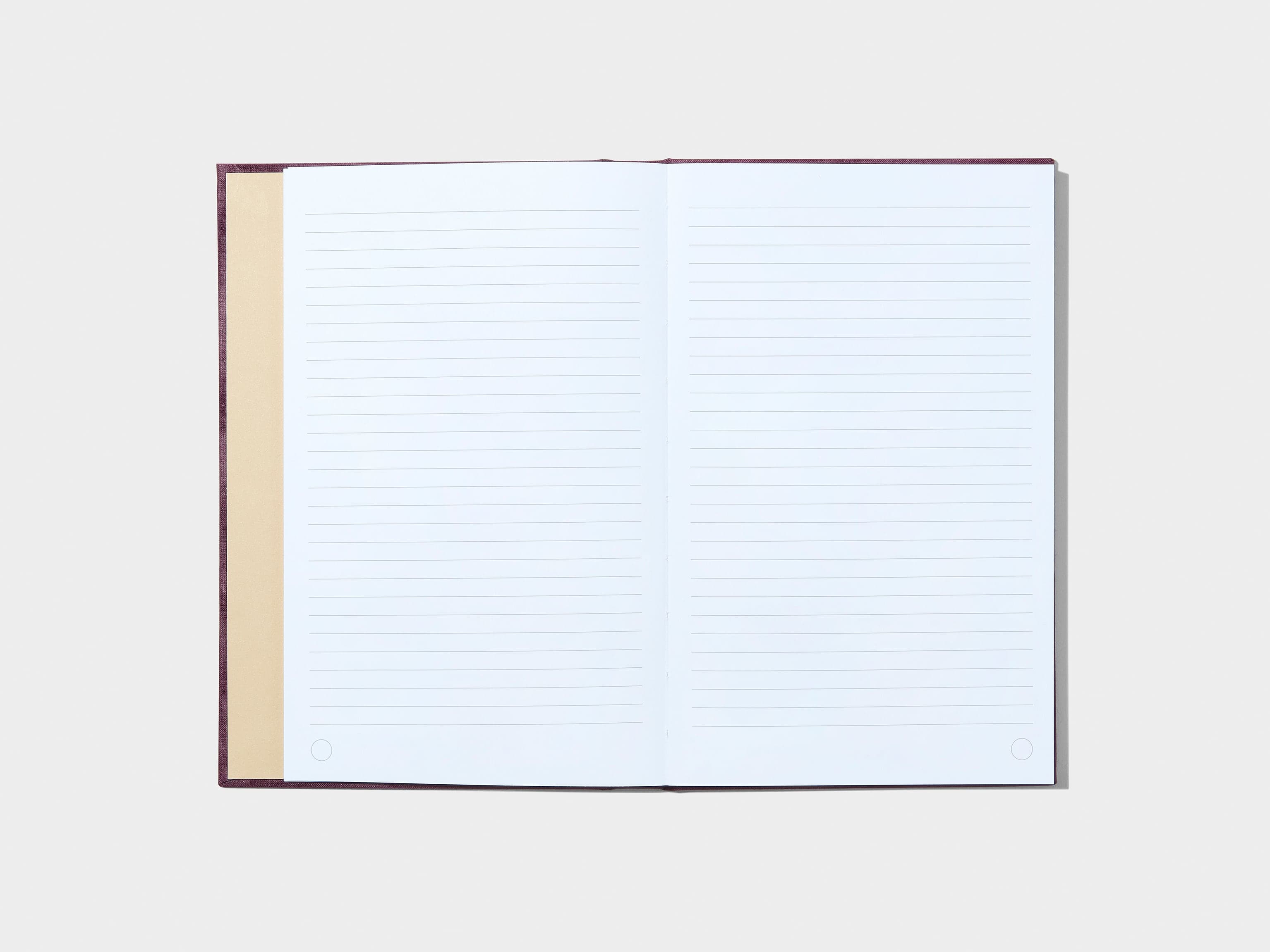 A mulberry coloured hardcover notebook laid flat open displaying white lined pages.