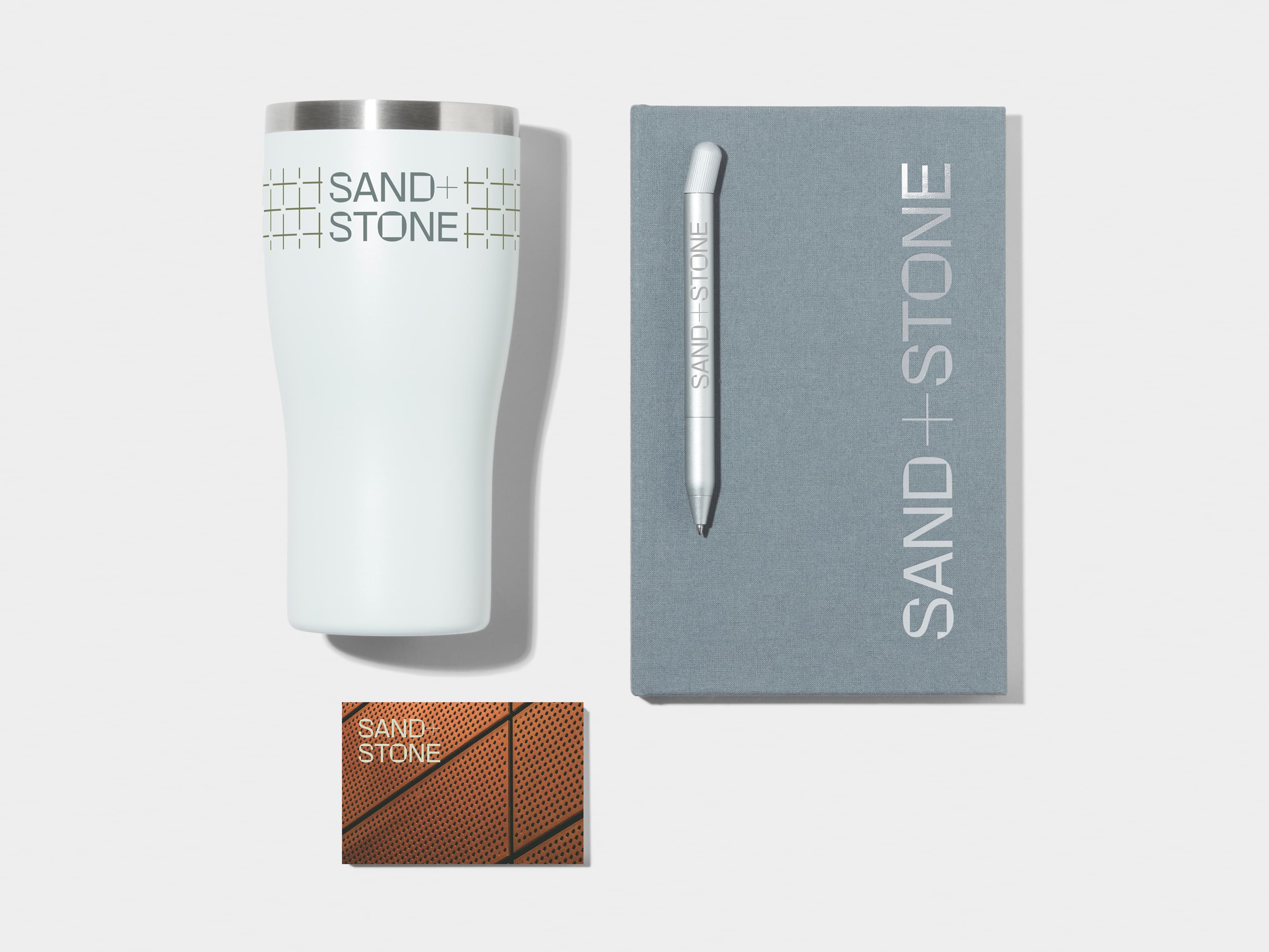 Insulated Tumbler in Cloudy Grey with 360 wrap printing customisation next to a Cloudy Grey Hard Cover Notebook, MOO Twist Pen and Business Card with custom branding