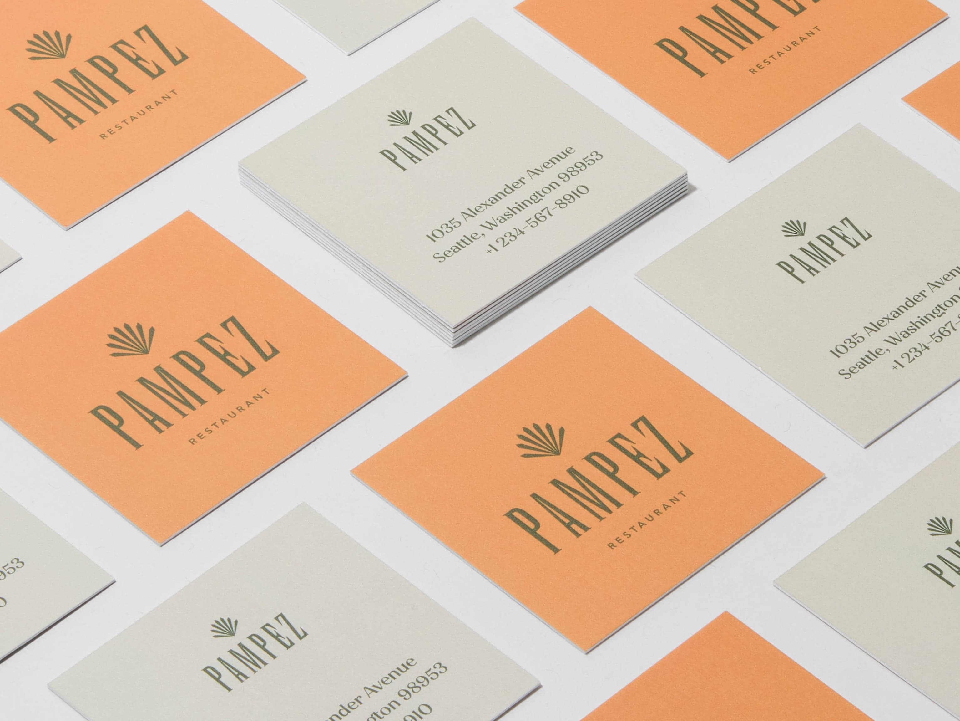 A collection of customised square luxe business cards placed across the image.