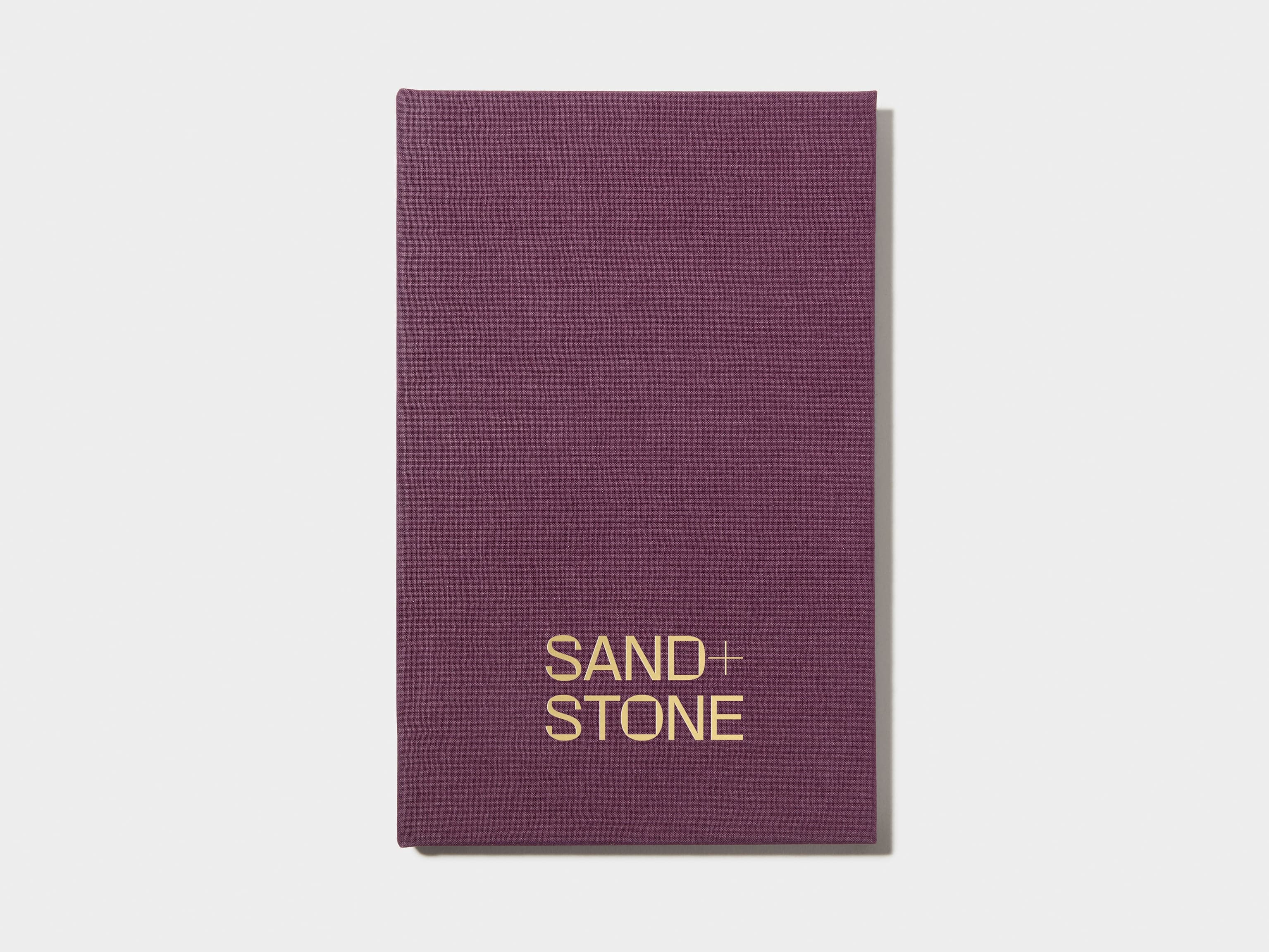 A mulberry coloured hardcover notebook with gold foil customisation on the front.