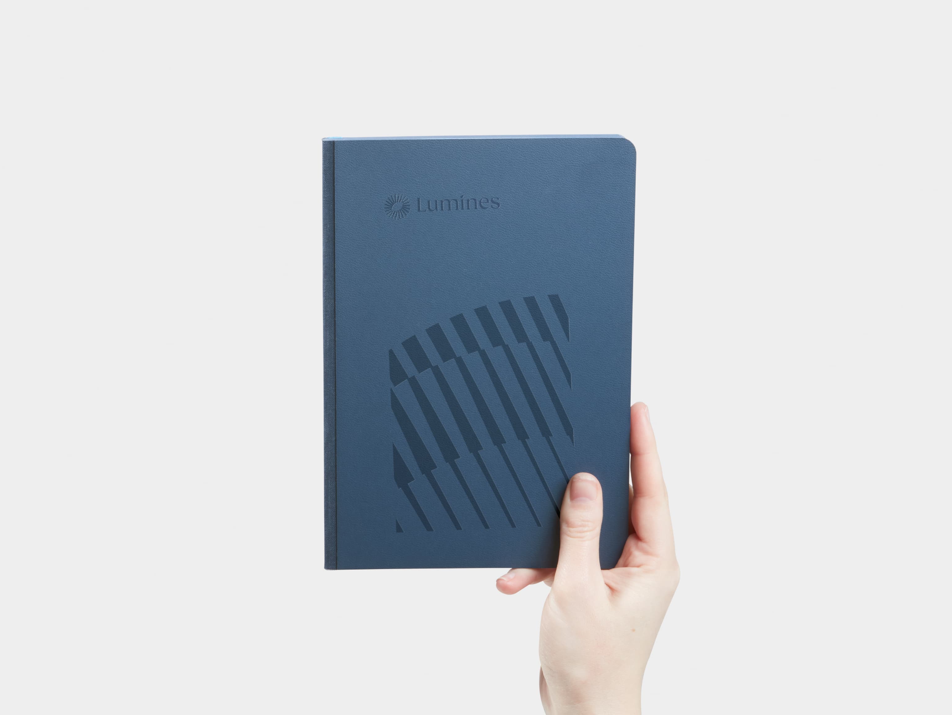 Hand holding Medium Midnight Blue MOO Softcover Notebook with Blind Deboss finish