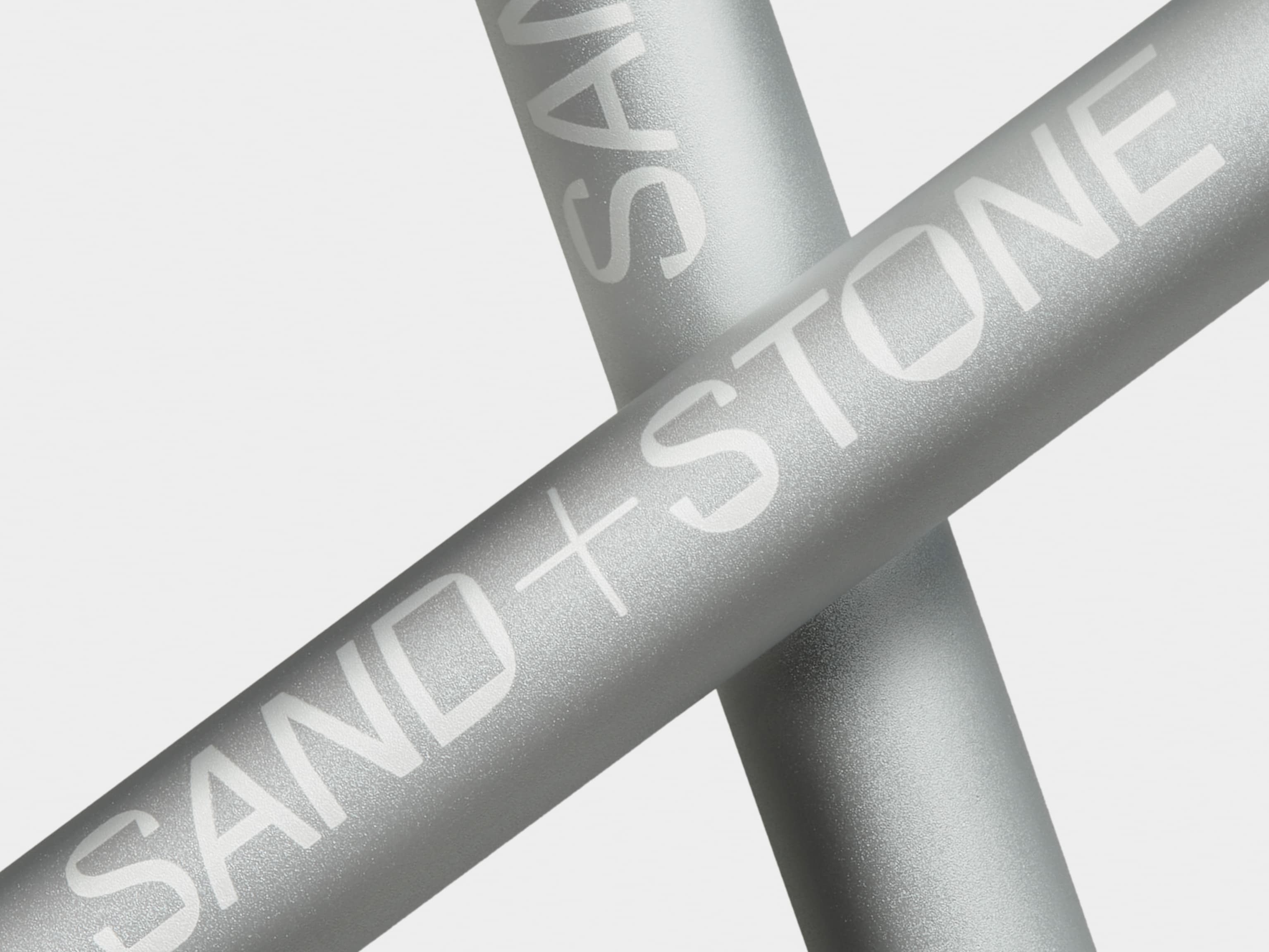 Detail image of two aluminium pens with custom white branding crossed over each other.