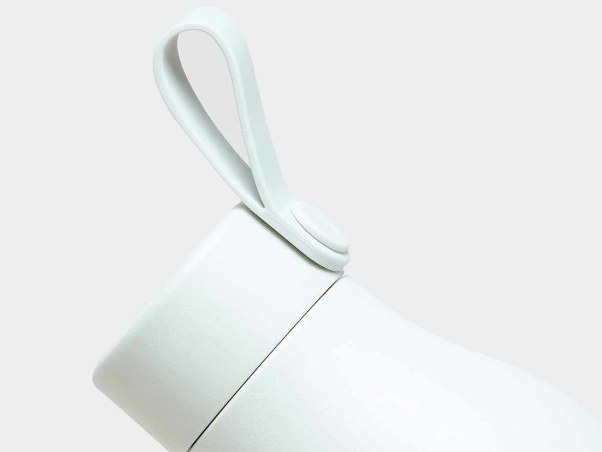 Close up image of the top of a cloudy grey MOO water bottle.