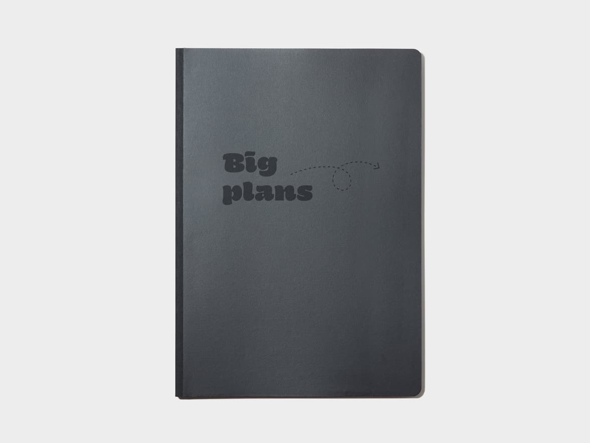 A black softcover planner with custom branding in deboss.