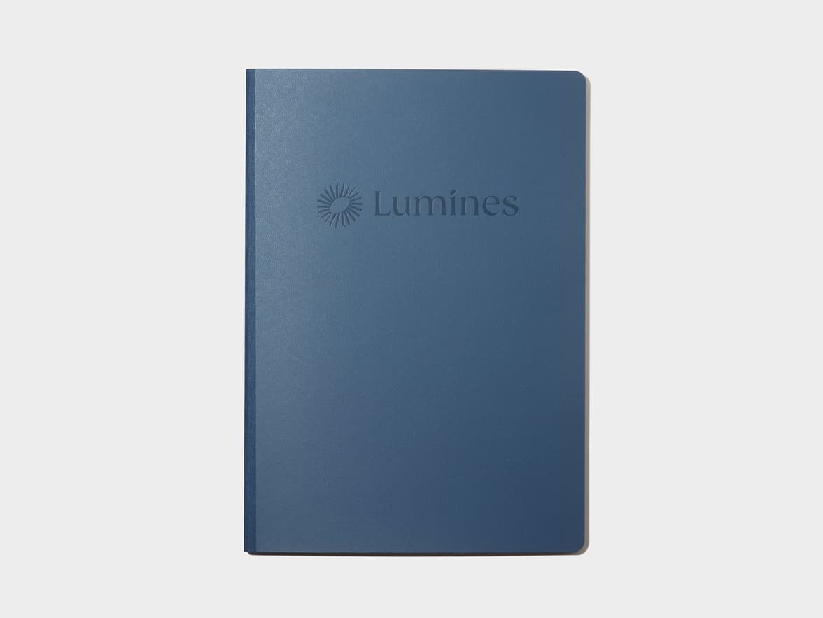 A blue softcover planner with custom branding in deboss.