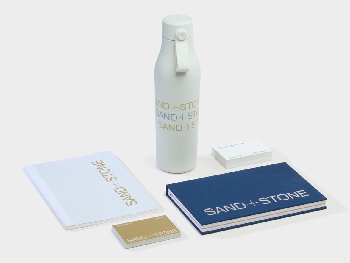 Collection of Branded Merchandise products including a water bottle, business cards and two notebooks.