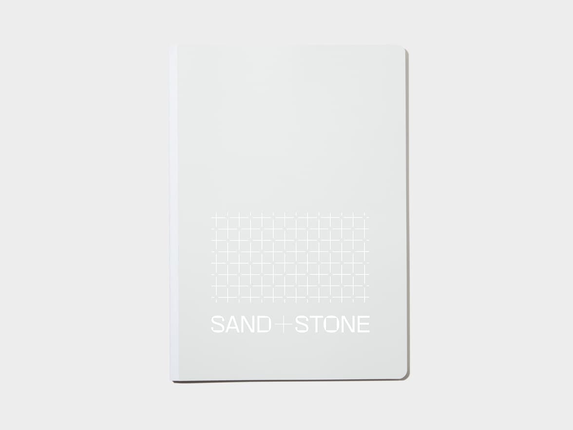 A large cloudy grey softcover notebook with white foil customisation.
