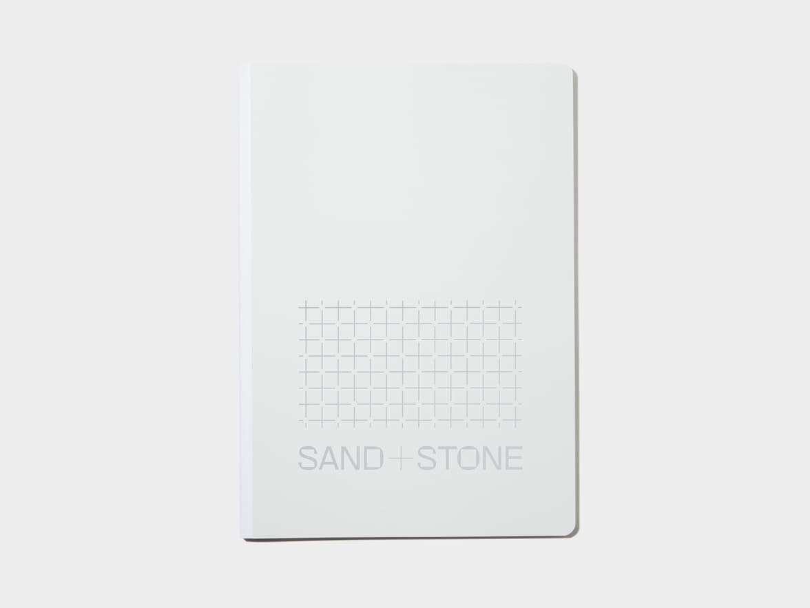 A large cloudy grey softcover notebook with silver foil customisation.